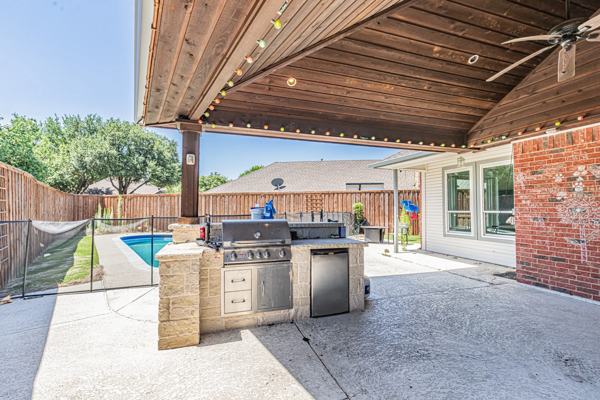 Covered patio featuring a wood-paneled ceiling with an integrated ceiling fan