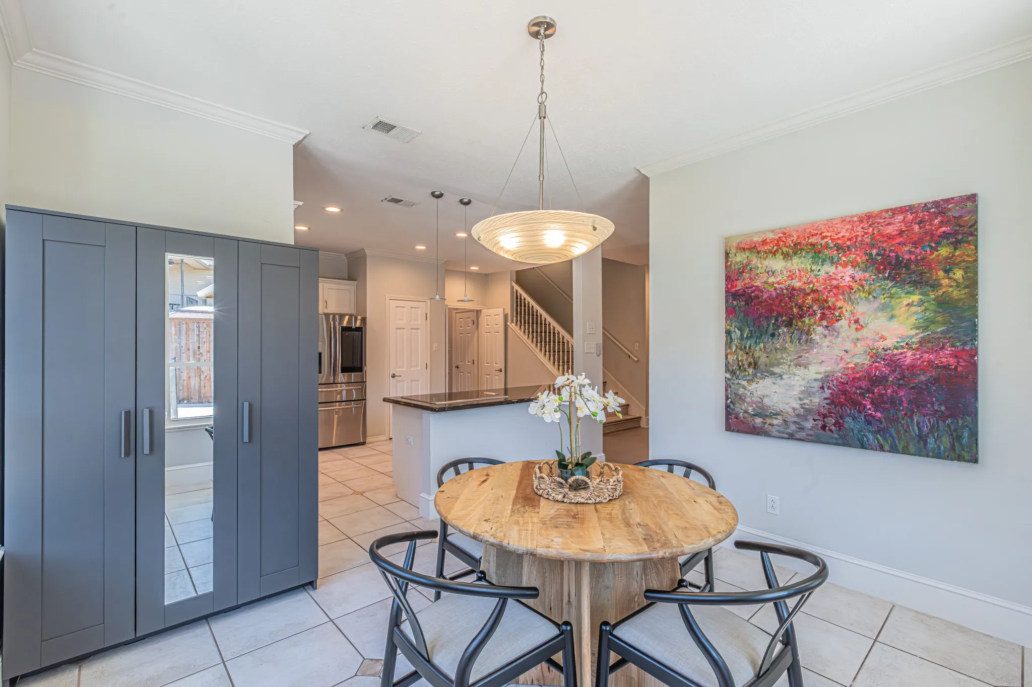 Crown molding details, tiled flooring, built-in cabinetry with mirrored panel, recessed lighting, and a contemporary pendant fixture