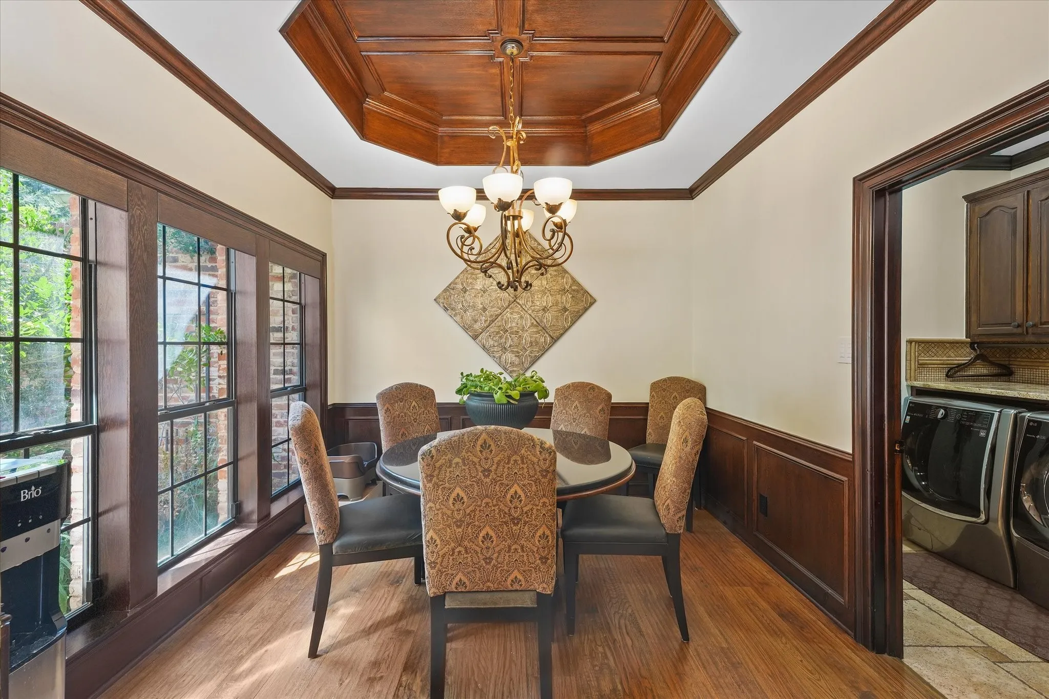 Breakfast area with a wood-paneled ceiling and windows overlooking the front patio.