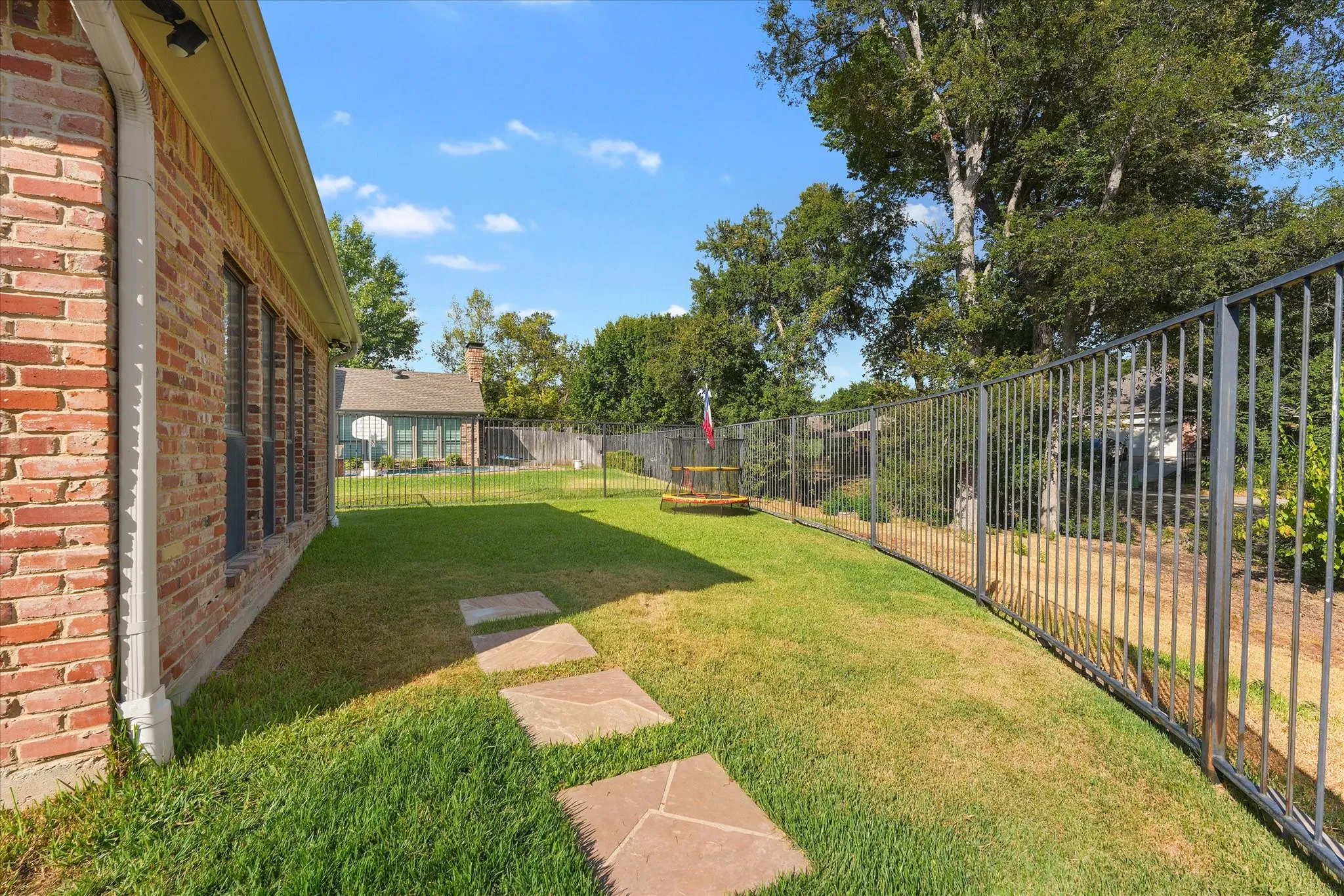 Rear lawn outside master bedroom along the home’s greenbelt-facing side.
