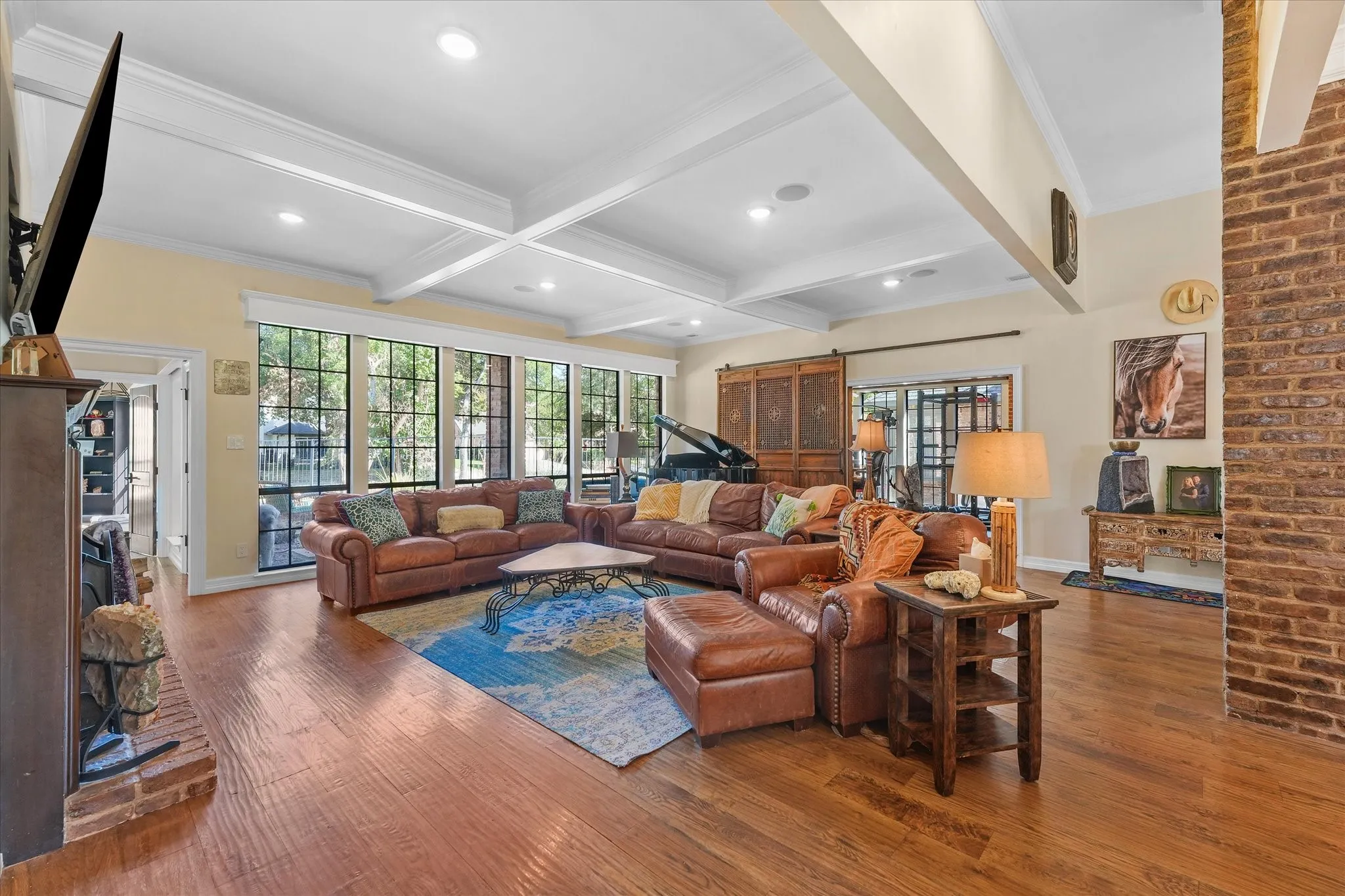 Spacious living room with a wood-burning fireplace and wide-plank hand-scraped white oak floors.