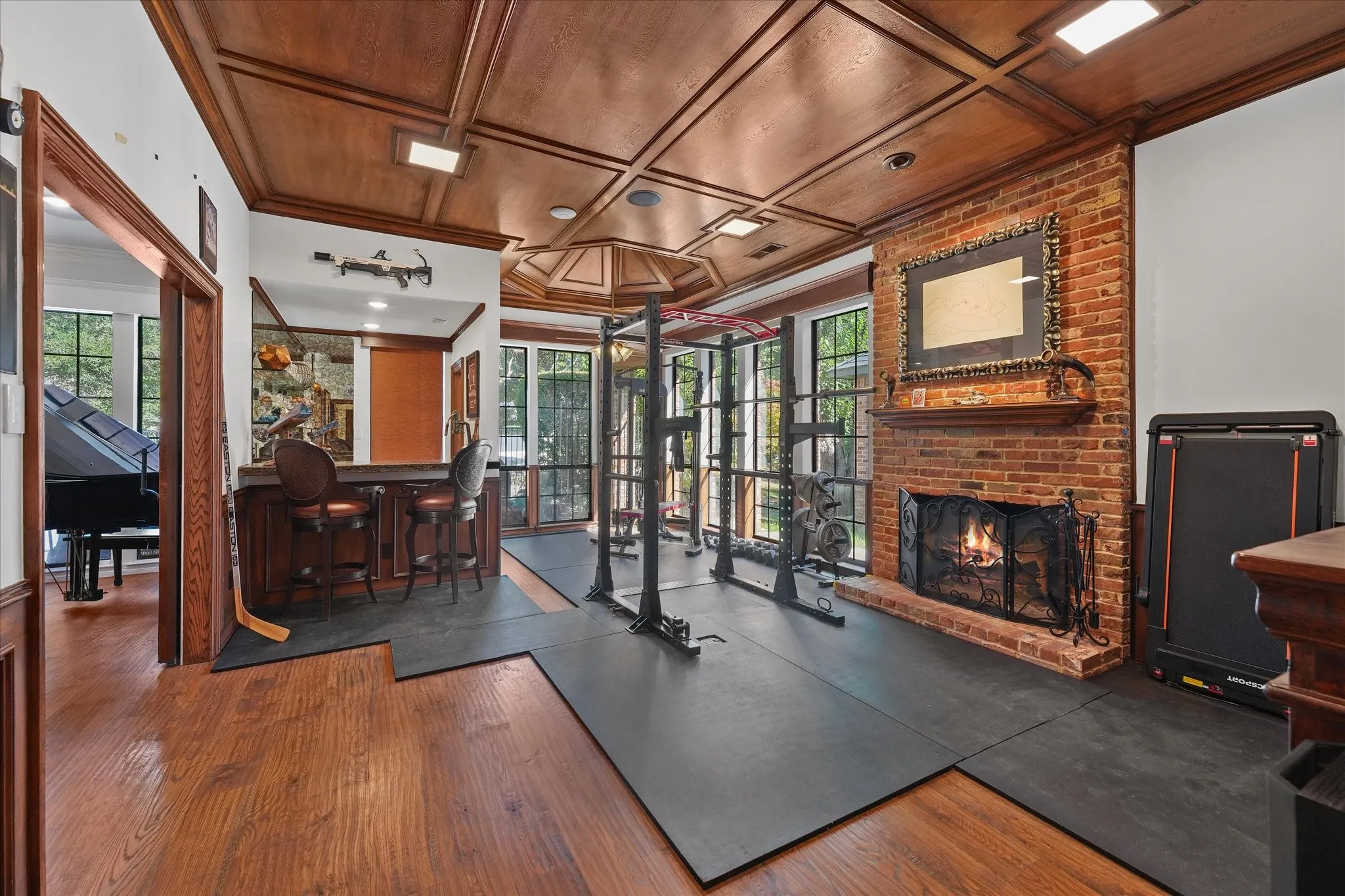 Vaulted den with a wood-paneled ceiling, wood-burning fireplace and custom wet bar.