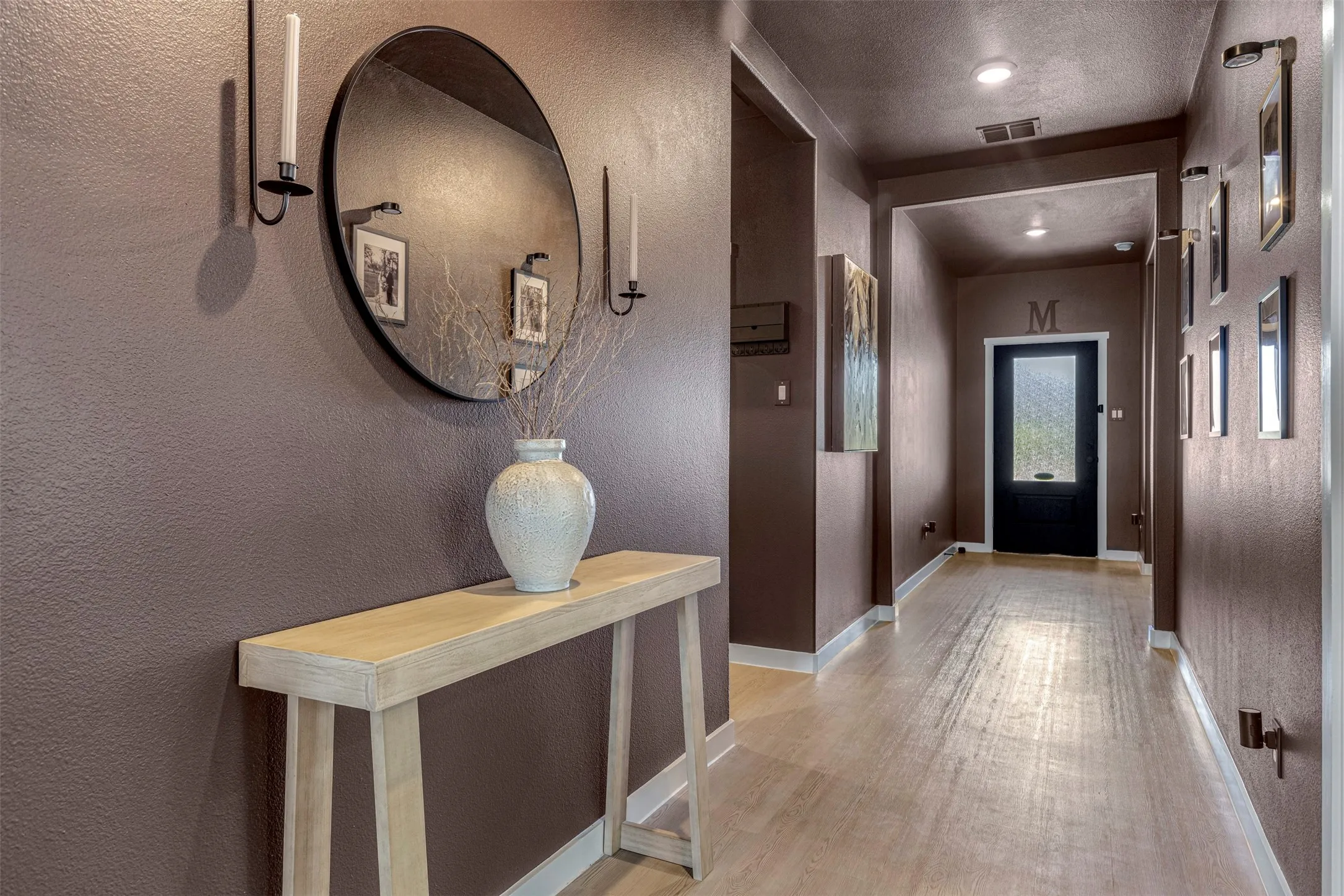 Hallway featuring textured walls, recessed lighting, and wood-finish flooring
