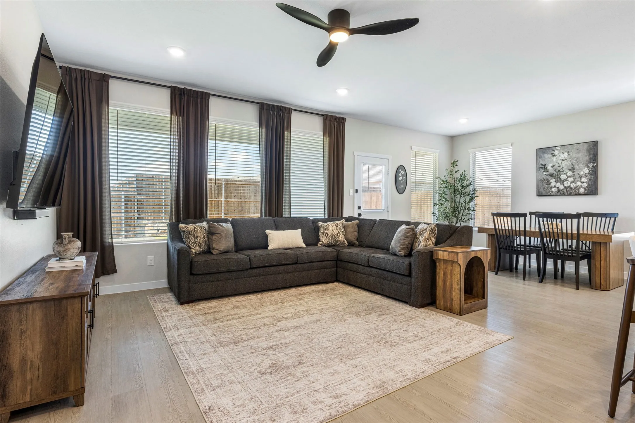 Recessed lighting, wood-finish flooring, ceiling fan, and multiple windows with blinds