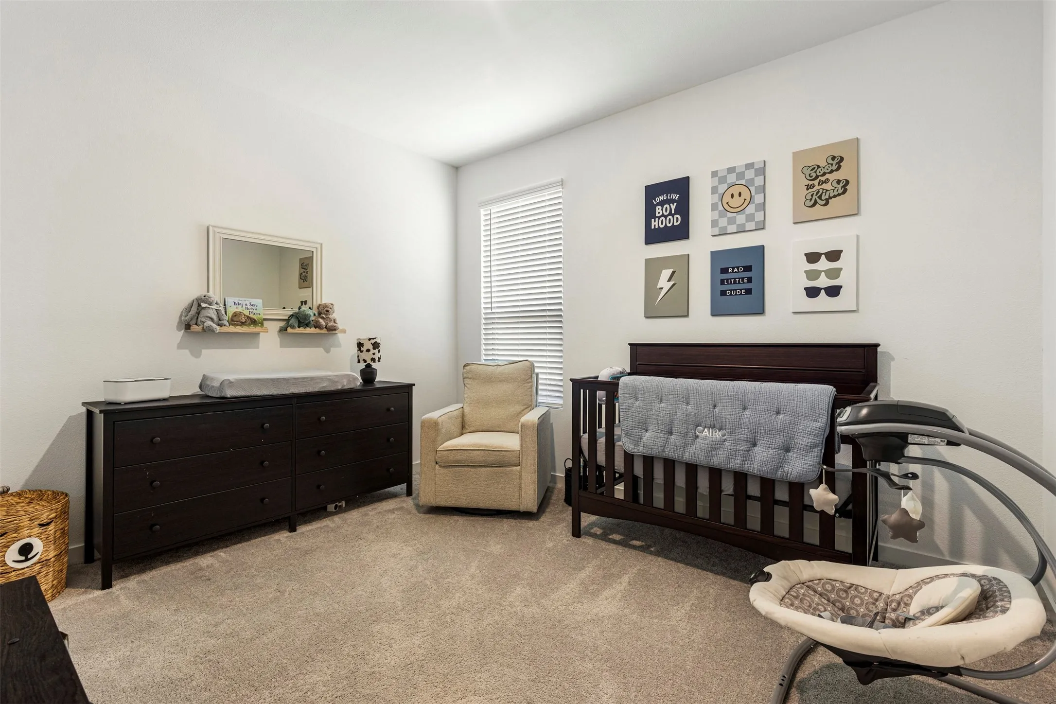 Light gray carpeted flooring, white walls, and a large window with blinds
