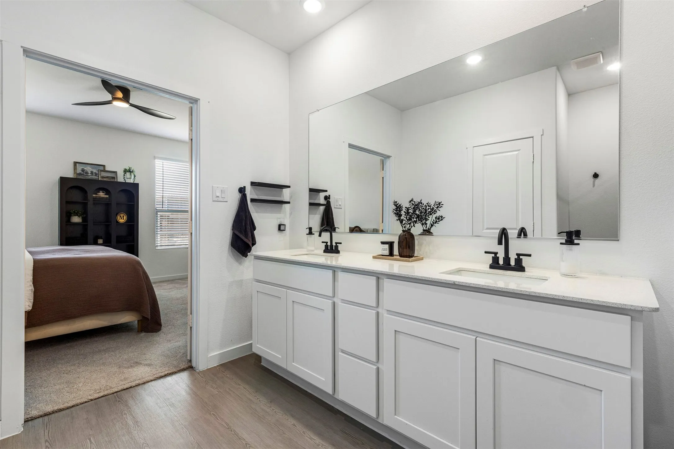 Dual vanity with white cabinetry and integrated sinks, complemented by a large wall-mounted mirror