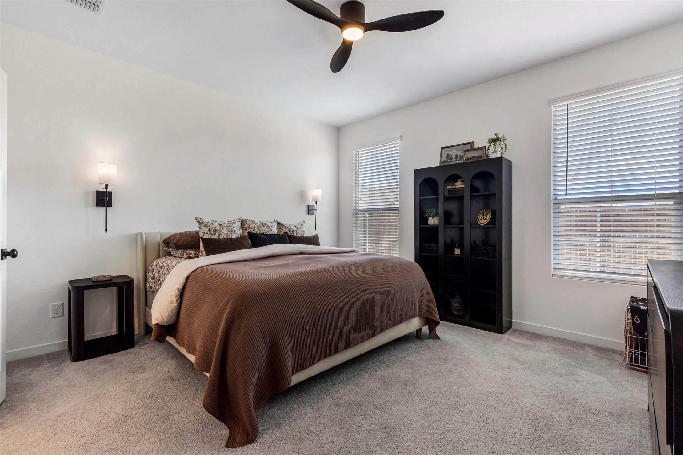 Recessed lighting, wall-mounted sconces, light-toned walls, and carpet flooring