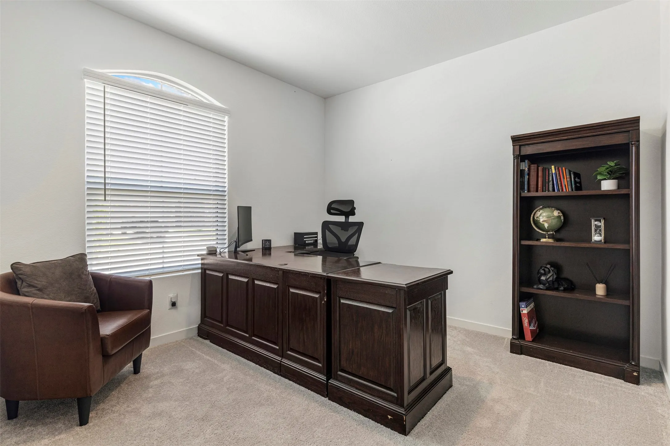Neutral wall color, carpeted flooring, window with arched transom, and integrated blinds