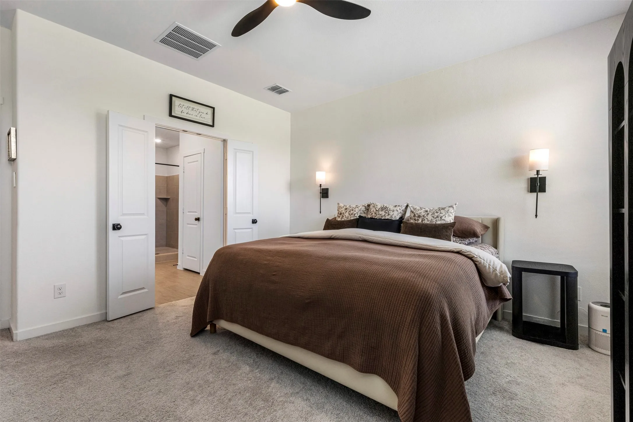 Plush carpet flooring, white walls, and a ceiling fan with integrated lighting