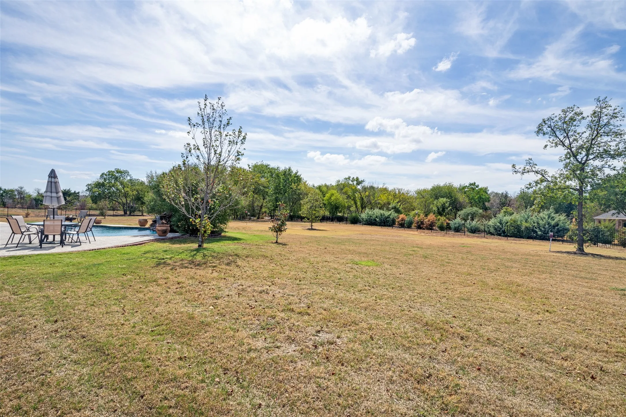 Large pie shaped lot with trees along the fence line for privacy