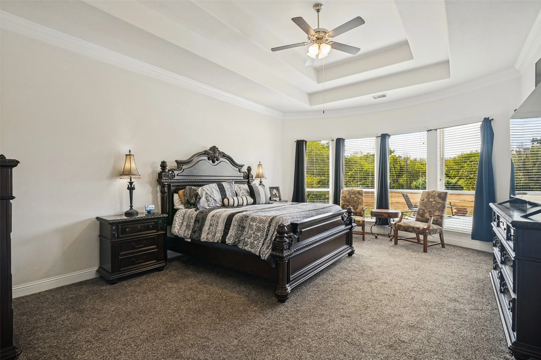Huge primary bedroom with circular bay window overlooking backyard.