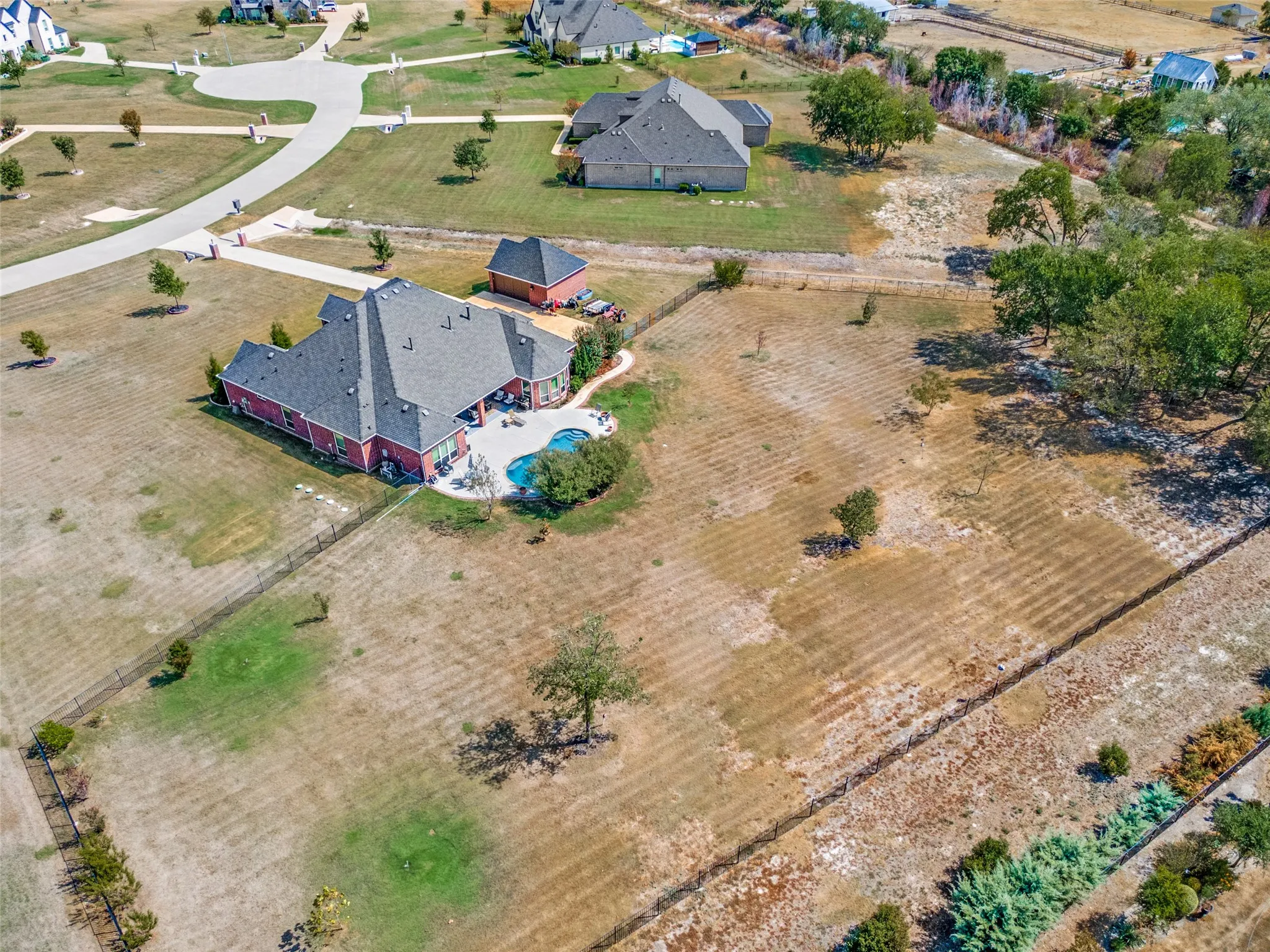 Aerial View of backyard showing home, pool and huge yard for playing.