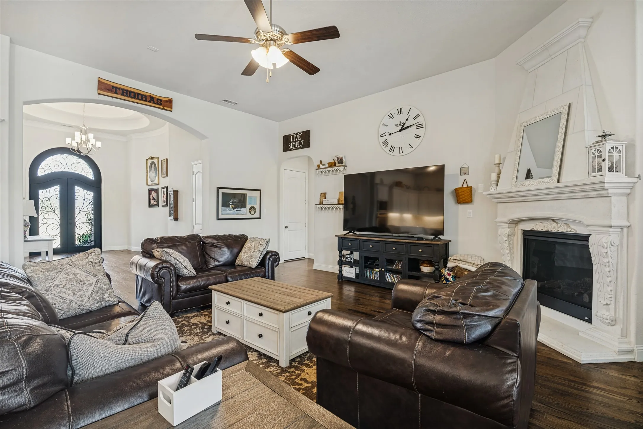 Family room with ornate cast stone fireplace surround and large wall for Television.