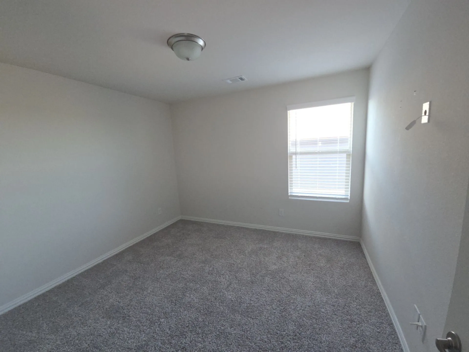 Recessed lighting, neutral wall paint, gray carpet flooring, window with blinds