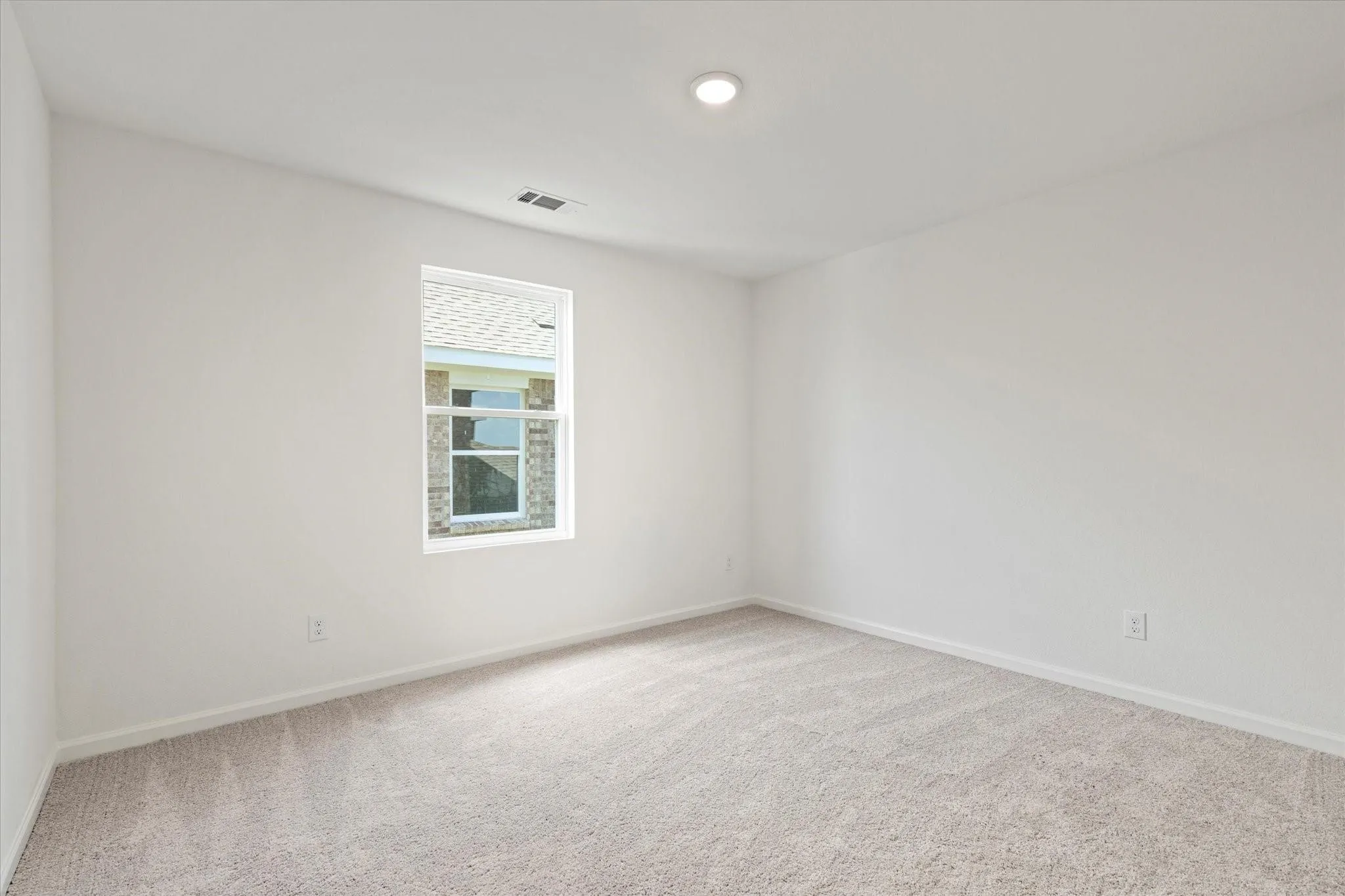 Recessed ceiling lighting, neutral wall finishes, light-toned carpeting, and a single pane window