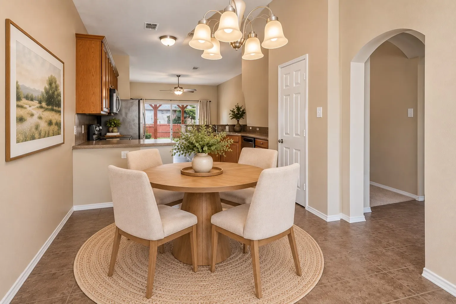 Open-concept dining space with a multi-light chandelier, tile flooring, and an arched entry