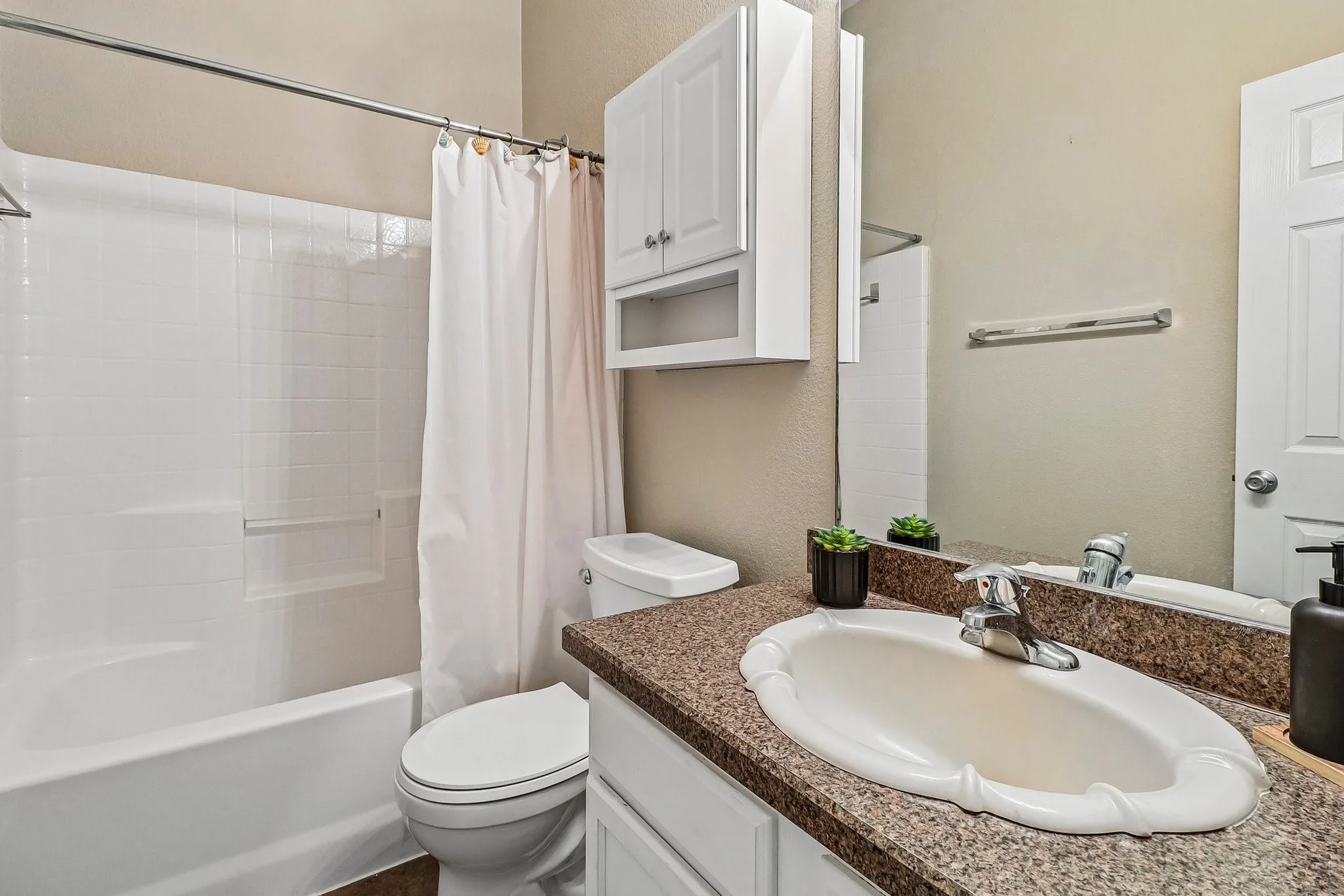 Integrated bathtub and shower with white subway tile surround