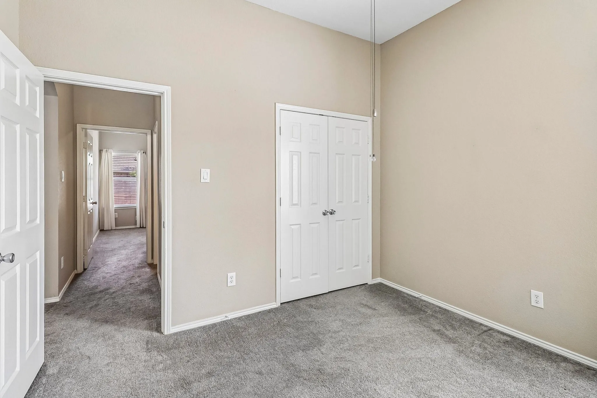 Vaulted ceiling, carpet flooring, neutral wall tones, white trim, and white paneled doors