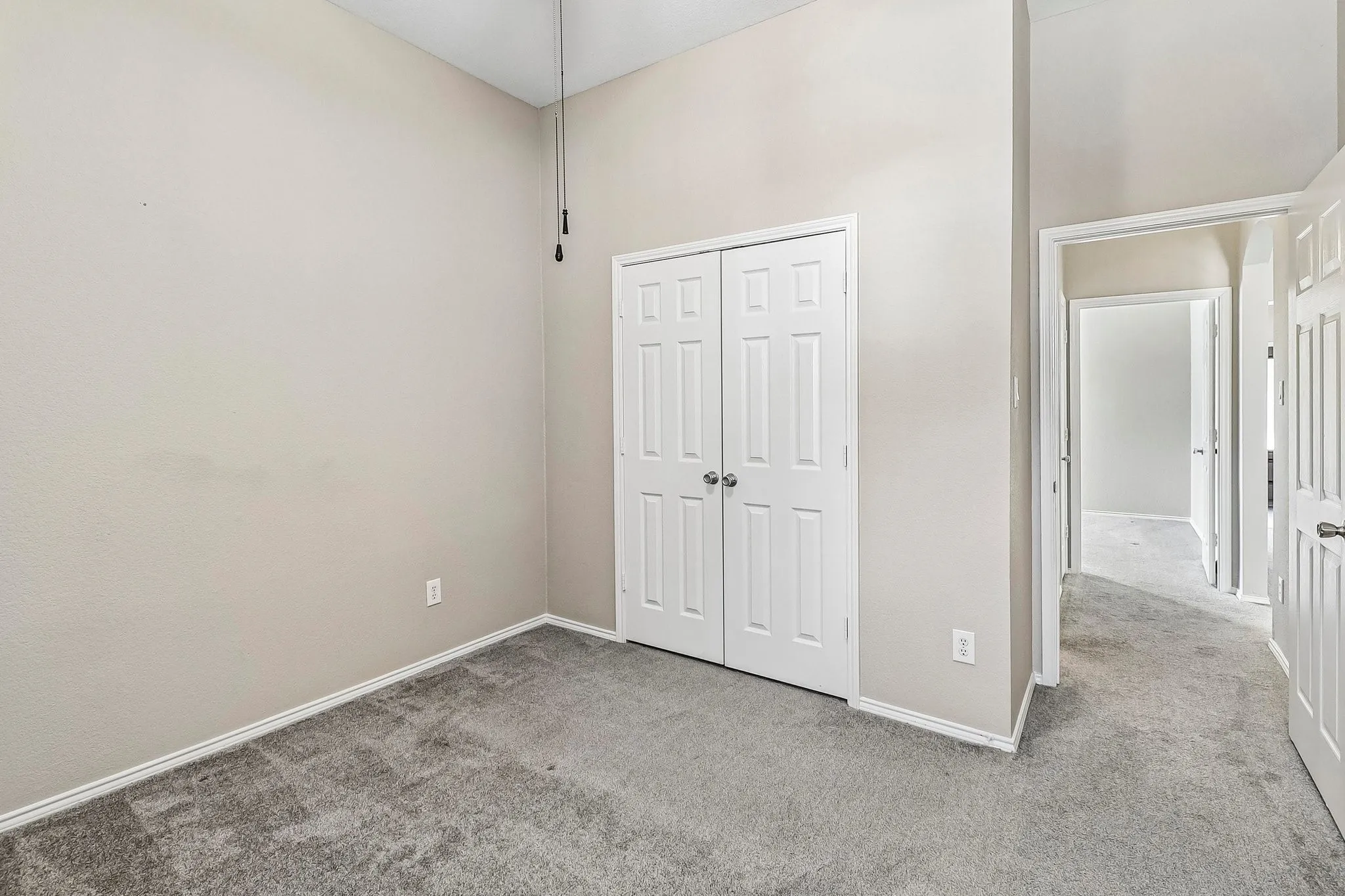 Vaulted ceiling with a ceiling fan, light gray wall finish, gray carpet flooring, and white paneled doors