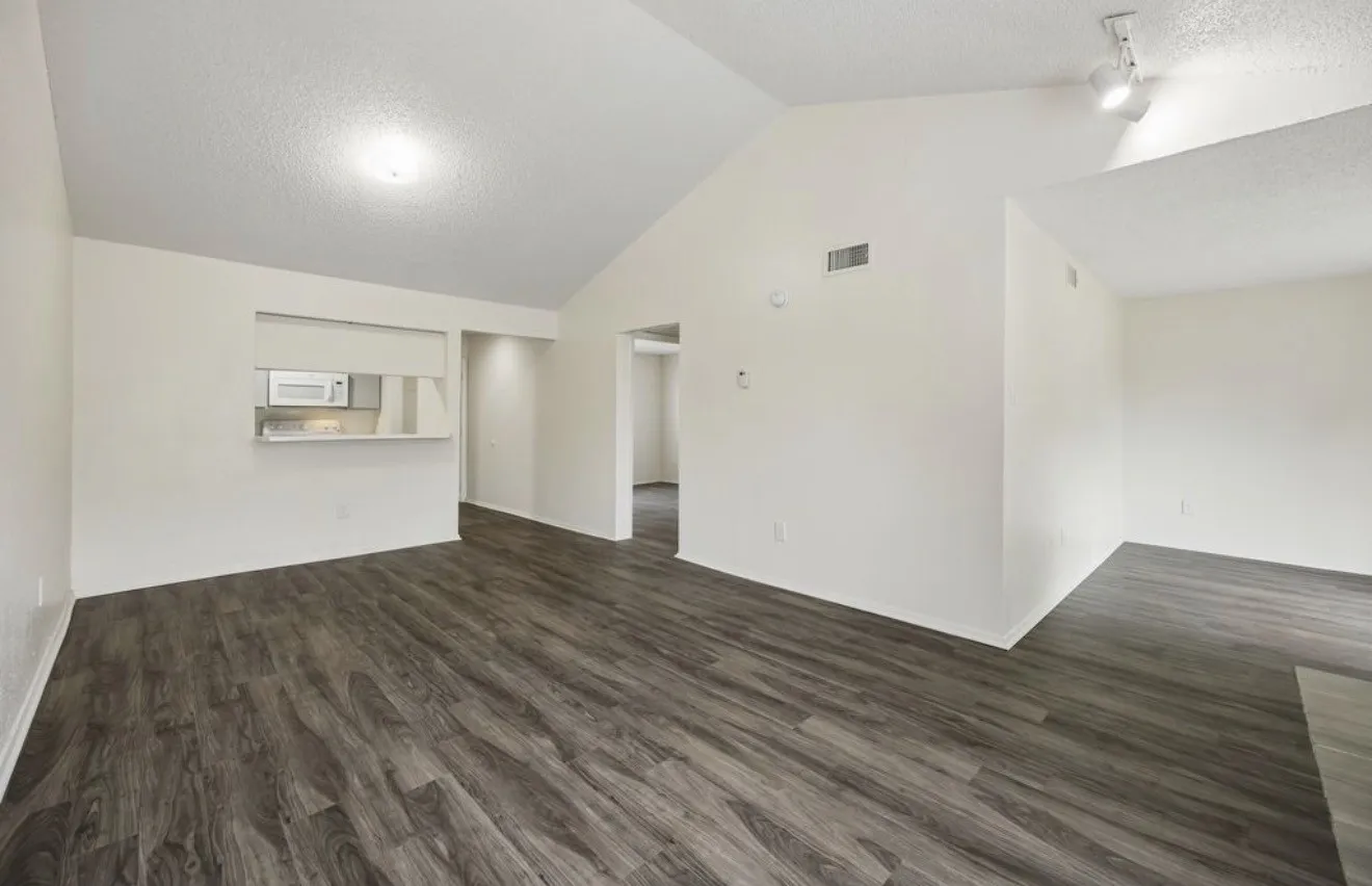 Vaulted ceiling, recessed lighting, track lighting, wood-finish flooring, and a pass-through window