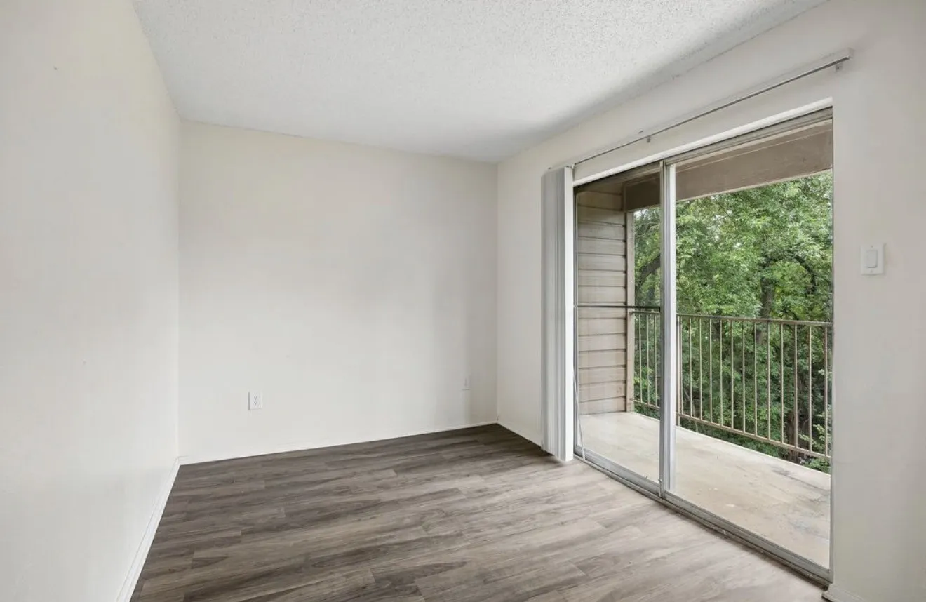 Room featuring wood-finish flooring, a neutral wall color, and a textured ceiling