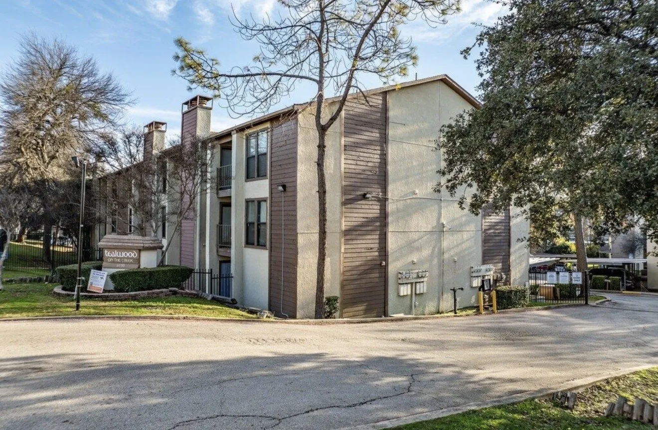 Multi-story building with textured stucco and wood-finish siding