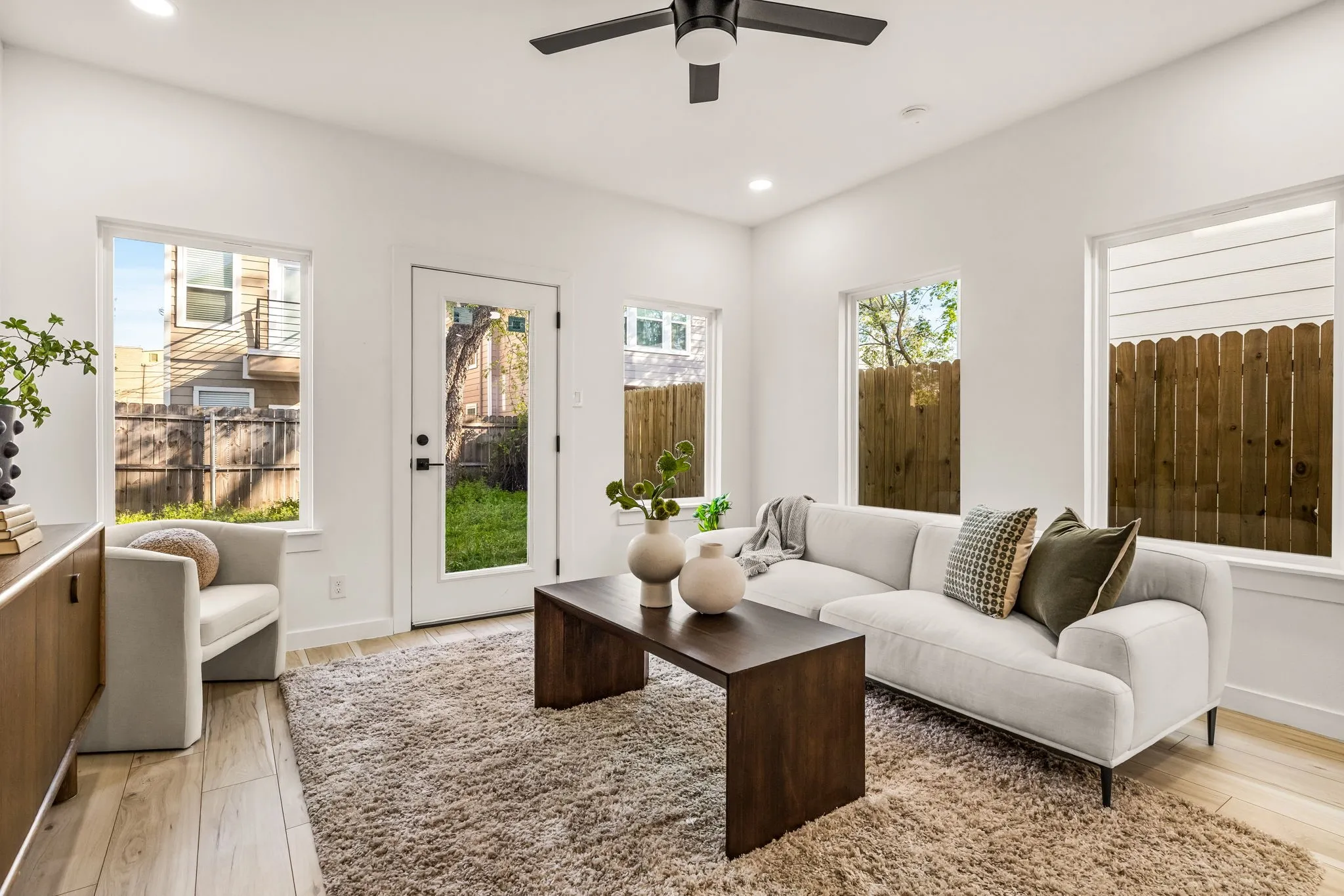 Recessed lighting, wood-finish flooring, ceiling fan, multiple windows, and a glass-paneled exterior door