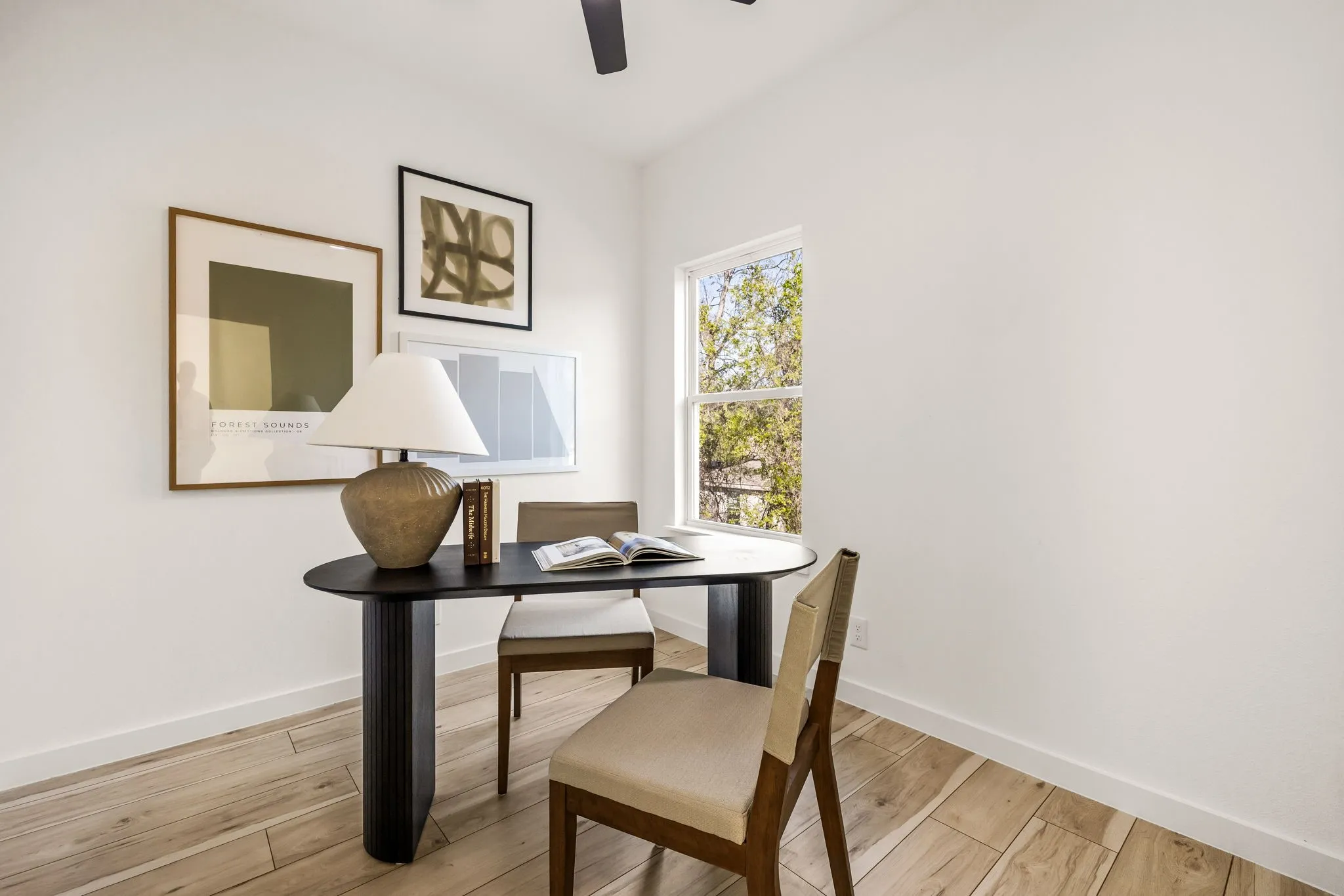 Wood-finish flooring, white walls, ceiling fan, and a double-pane window