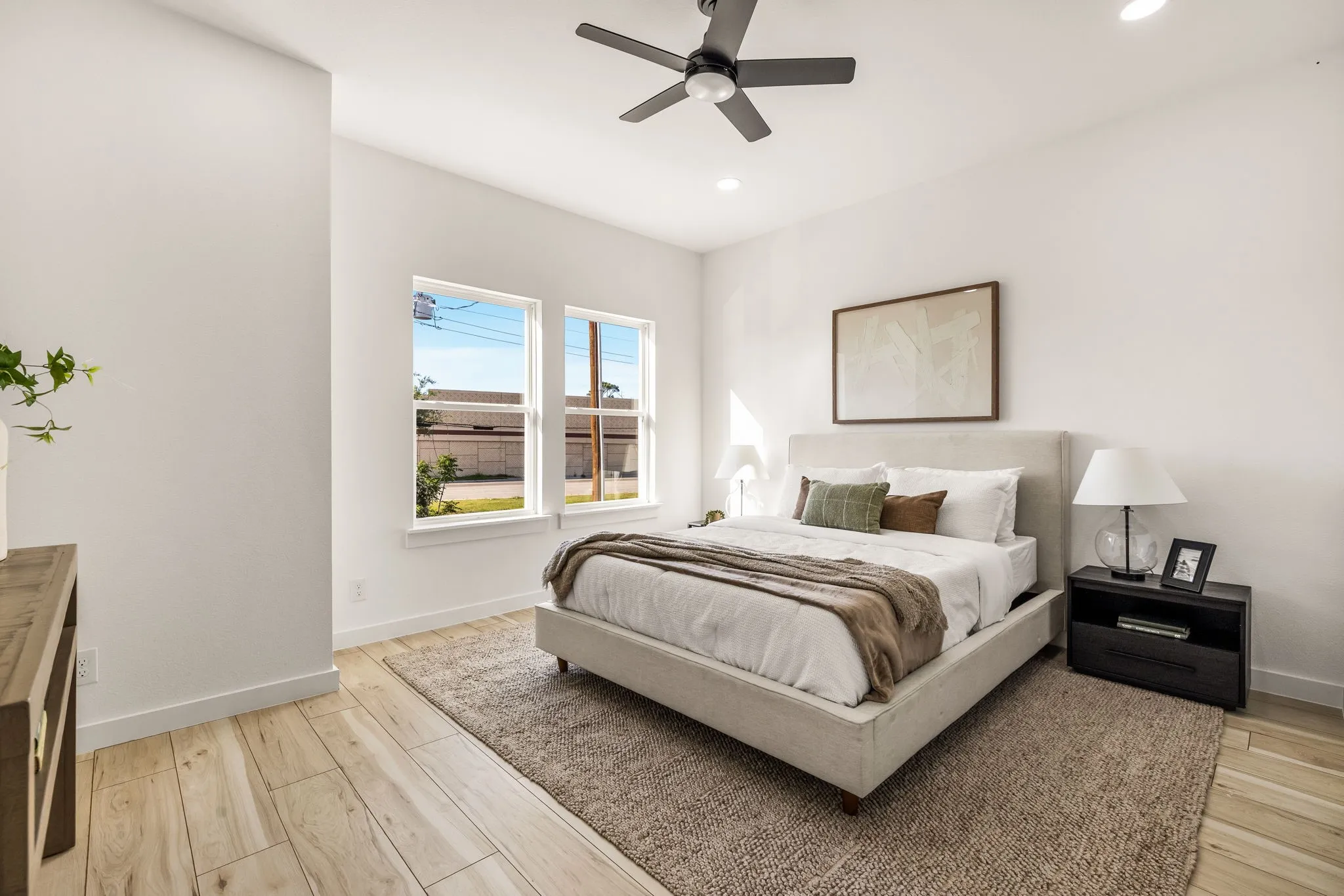 Spacious room featuring wood-finish flooring, recessed lighting, a ceiling fan, and multiple windows