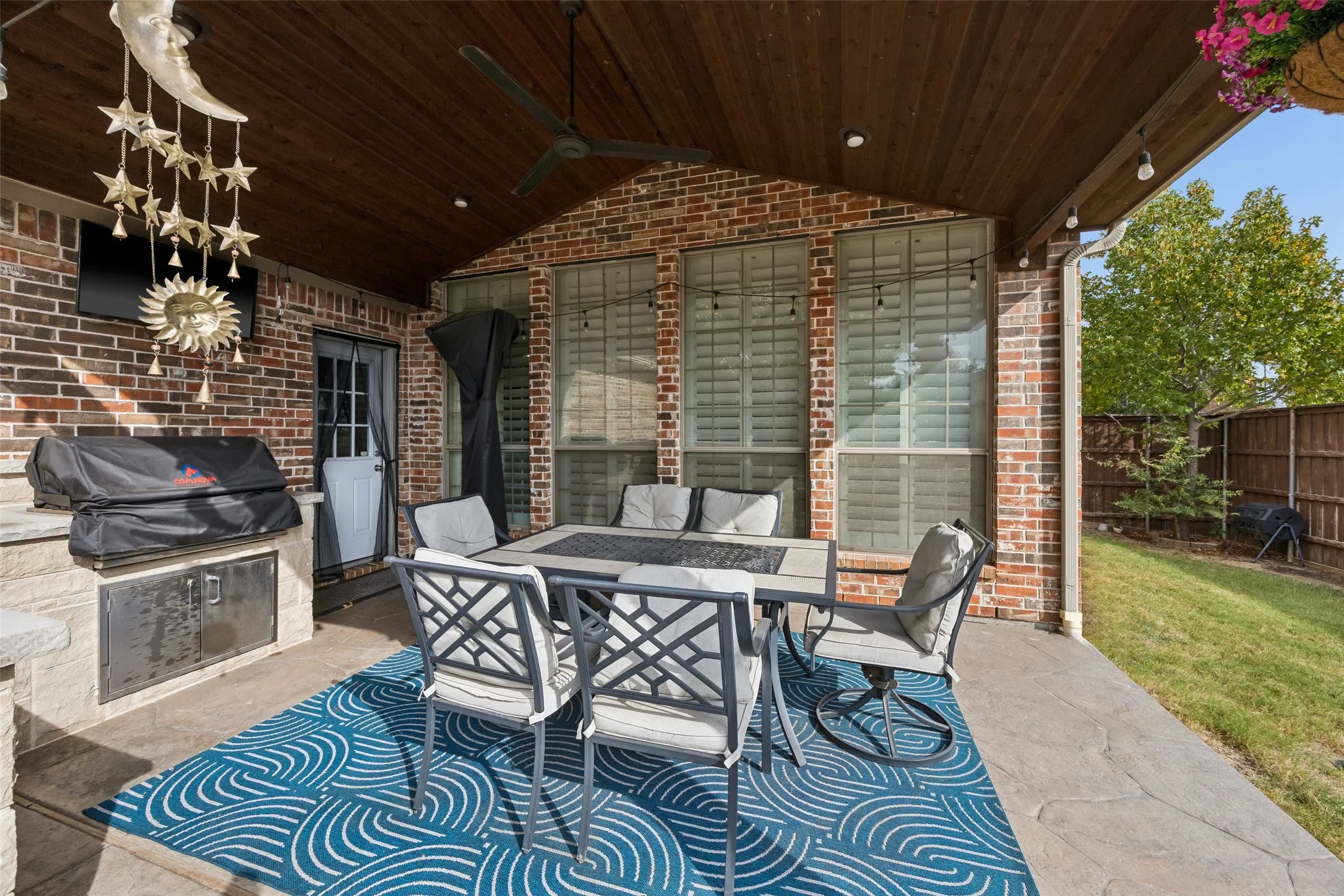 Covered patio featuring a wood-finish ceiling, ceiling fan, recessed lighting, and brick exterior