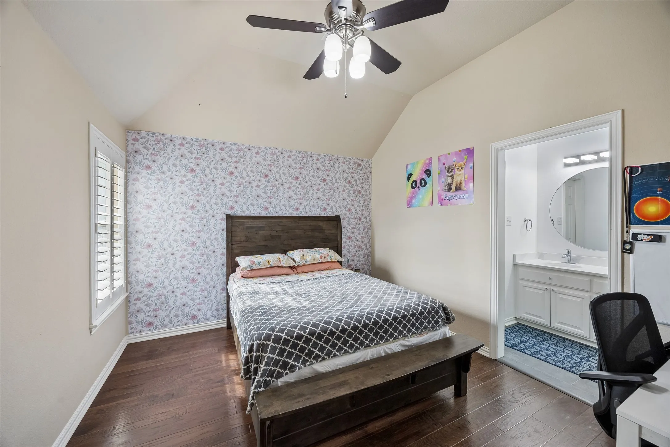 Vaulted ceiling with a ceiling fan, wood-finish flooring, and white window shutters