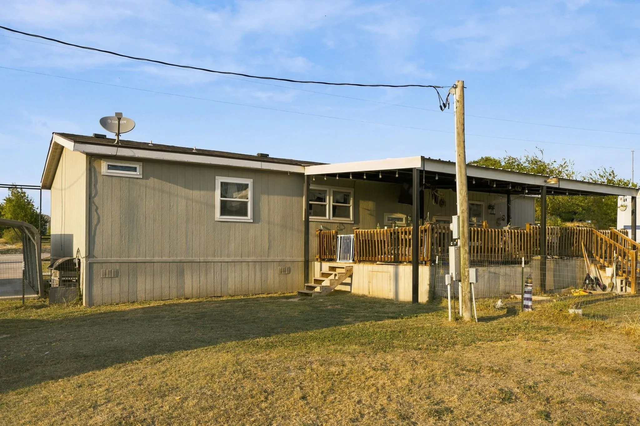 Expansive outdoor deck with wood railings, covered patio, and exterior siding
