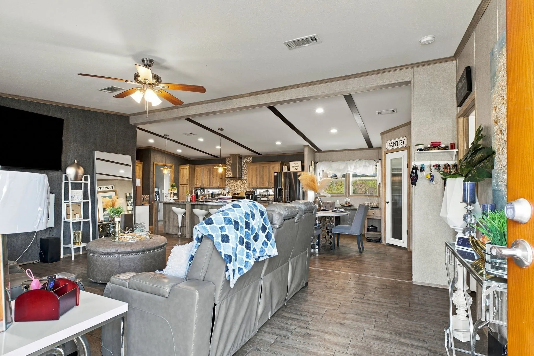 Open-concept living area with wood-finish flooring, a ceiling fan, and recessed lighting