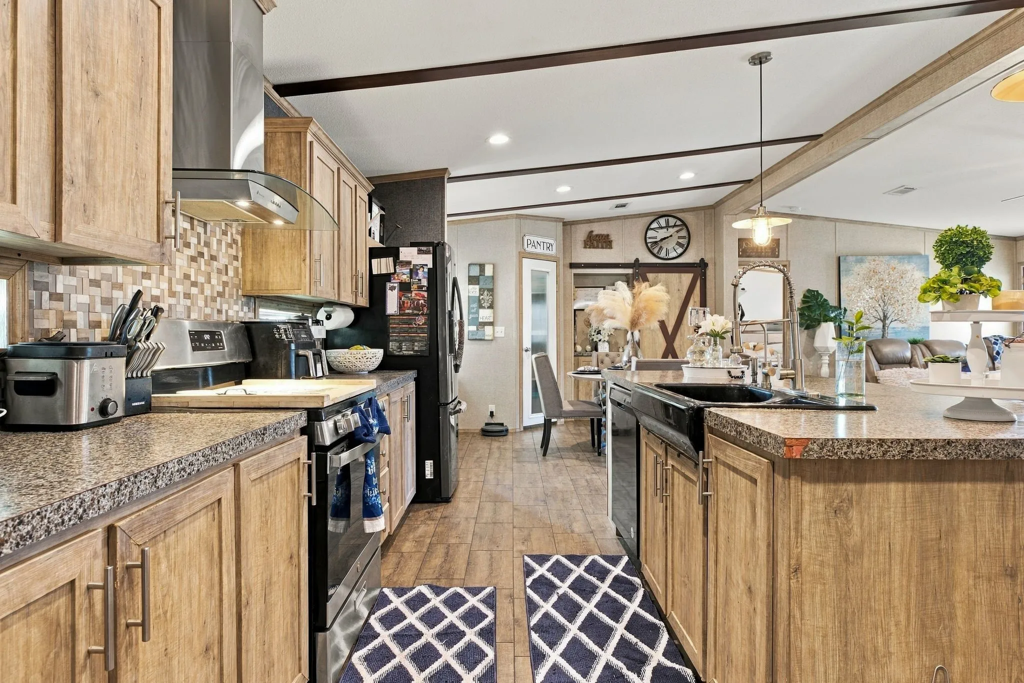 Kitchen featuring wood-finish cabinetry, speckled countertops, and a tiled backsplash