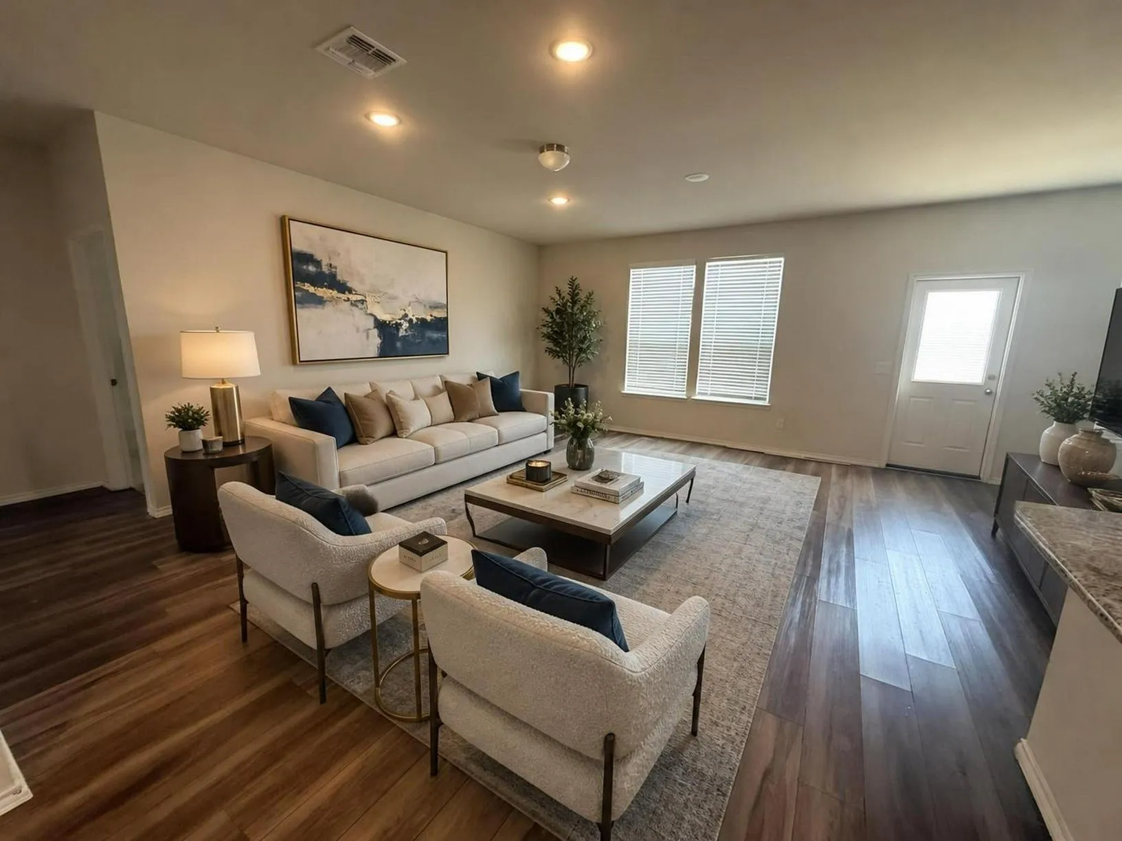 Spacious living area featuring wood-finish flooring, recessed lighting, and ample natural light from multiple windows