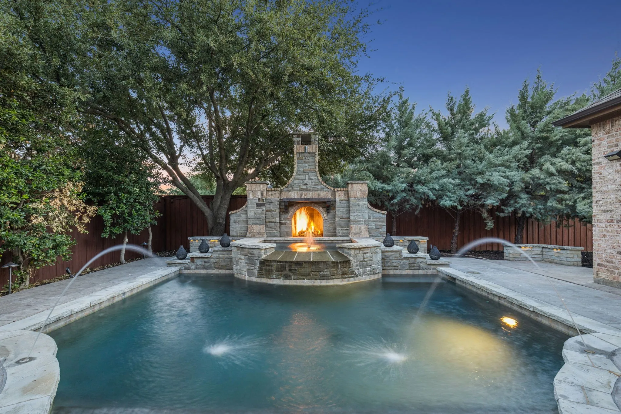 Captivating fireplace as the centerpiece of the pool, with gorgeous fountain streams