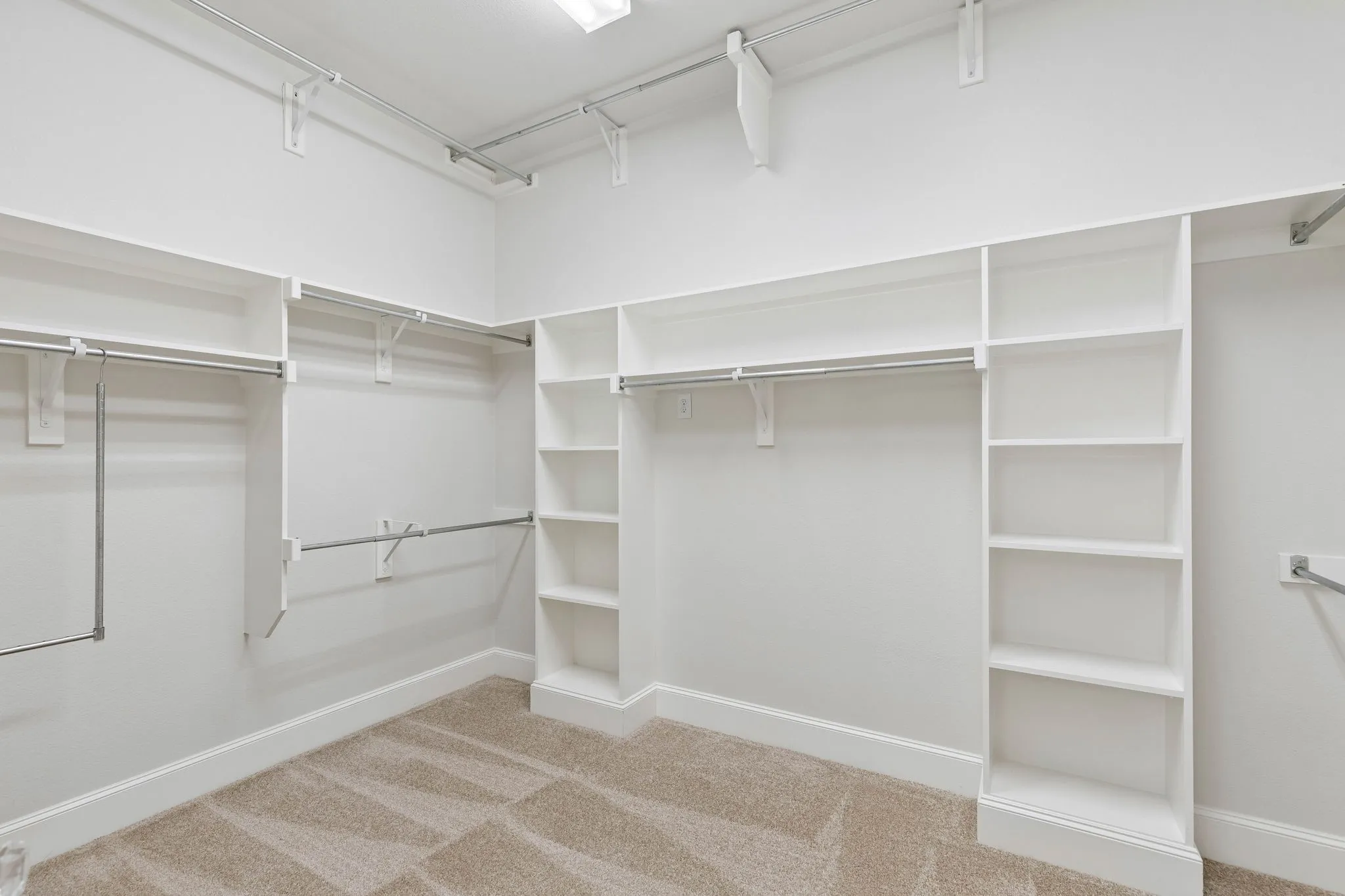 Large primary closet, with plenty of storage space and shelving