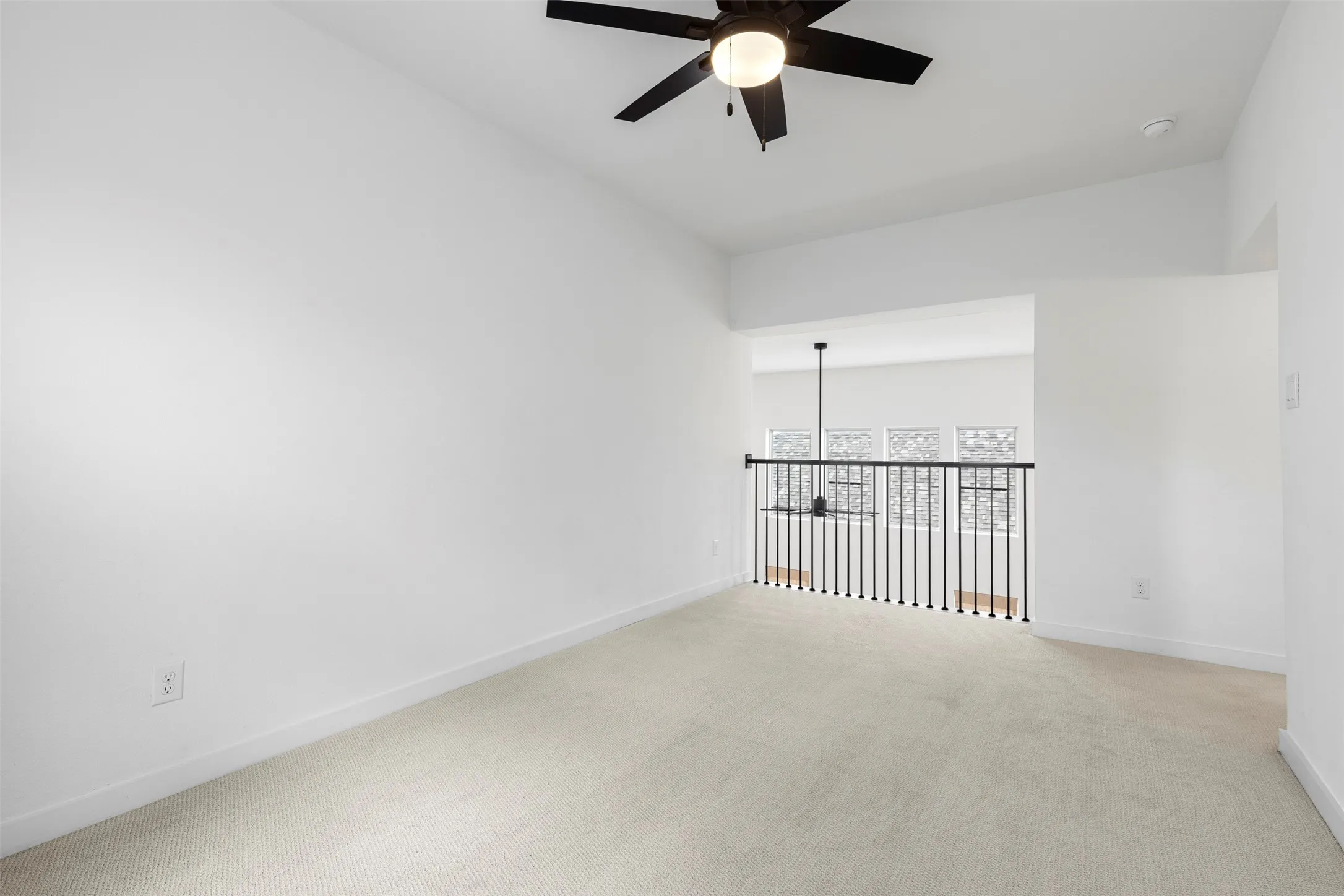 Carpeted flooring with white walls and a ceiling fan