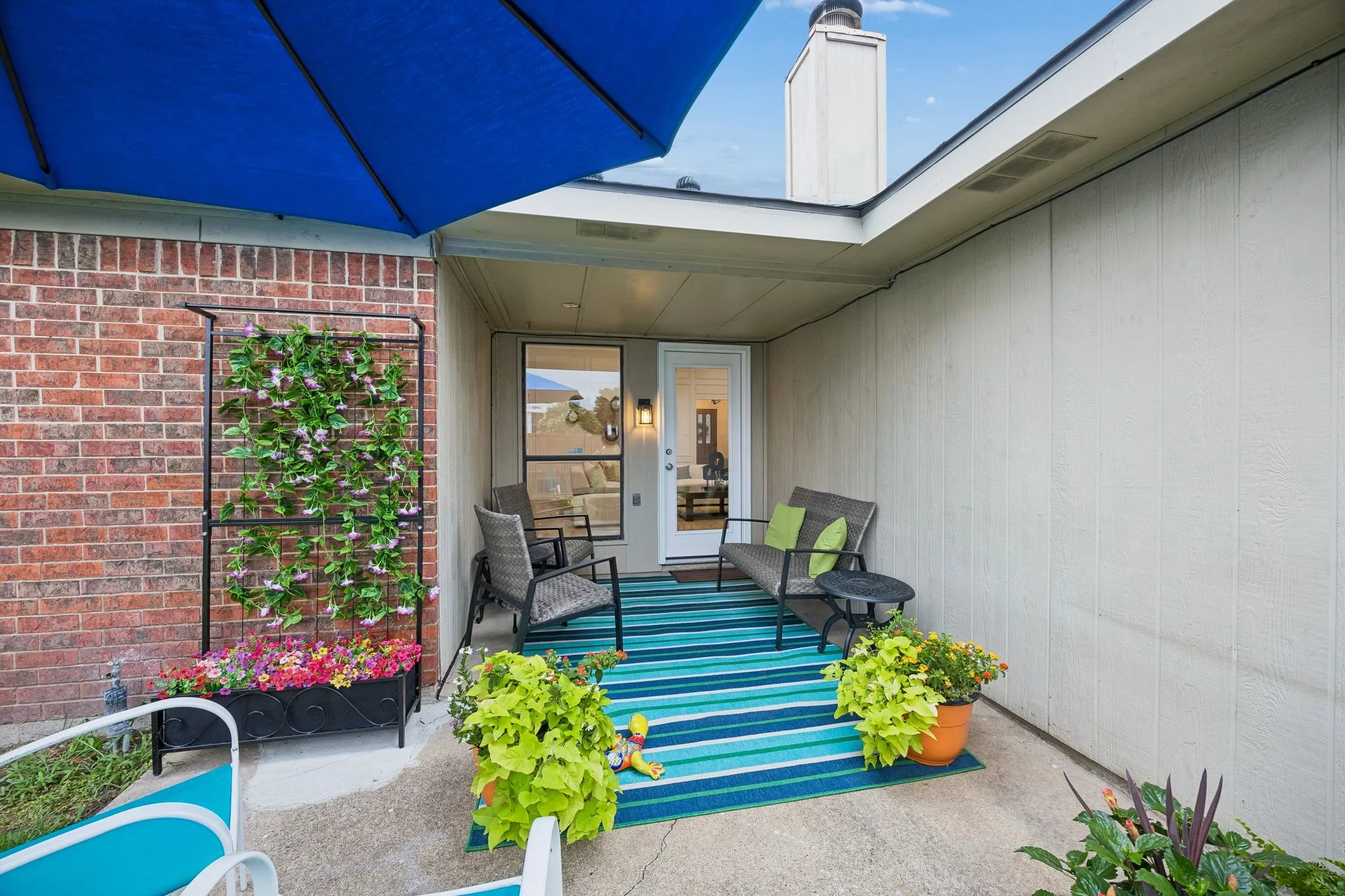Covered patio with a concrete surface, brick wall, and board and batten siding