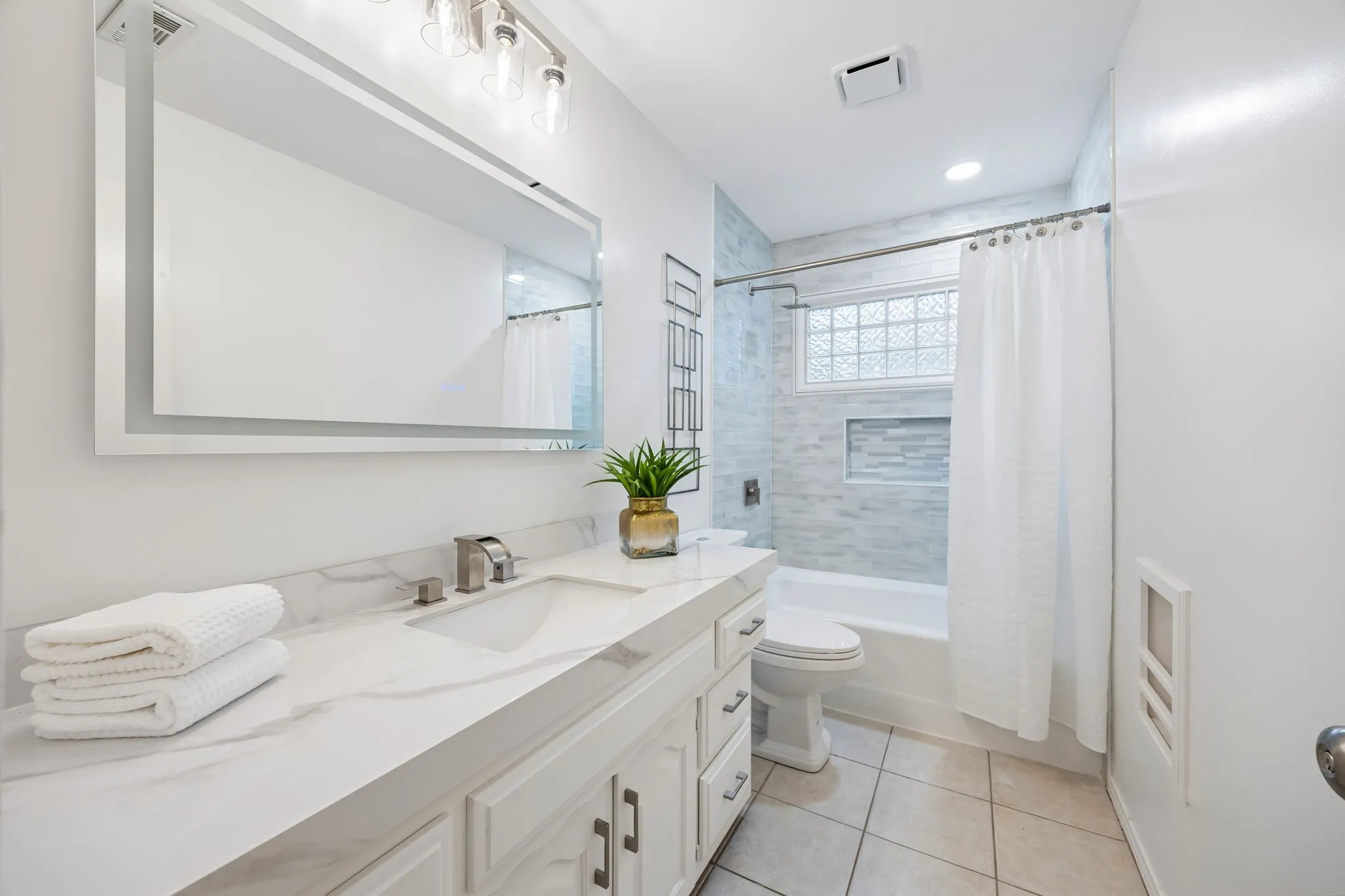 Vanity with a solid surface countertop, undermount sink, and brushed nickel faucet