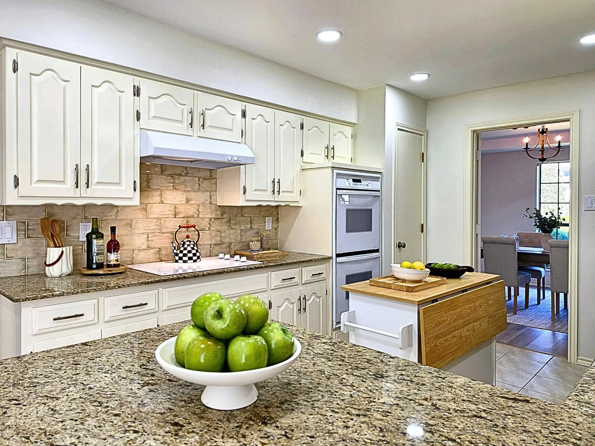 Kitchen featuring white cabinetry, granite countertops, a tiled backsplash, built-in double ovens, and recessed lighting