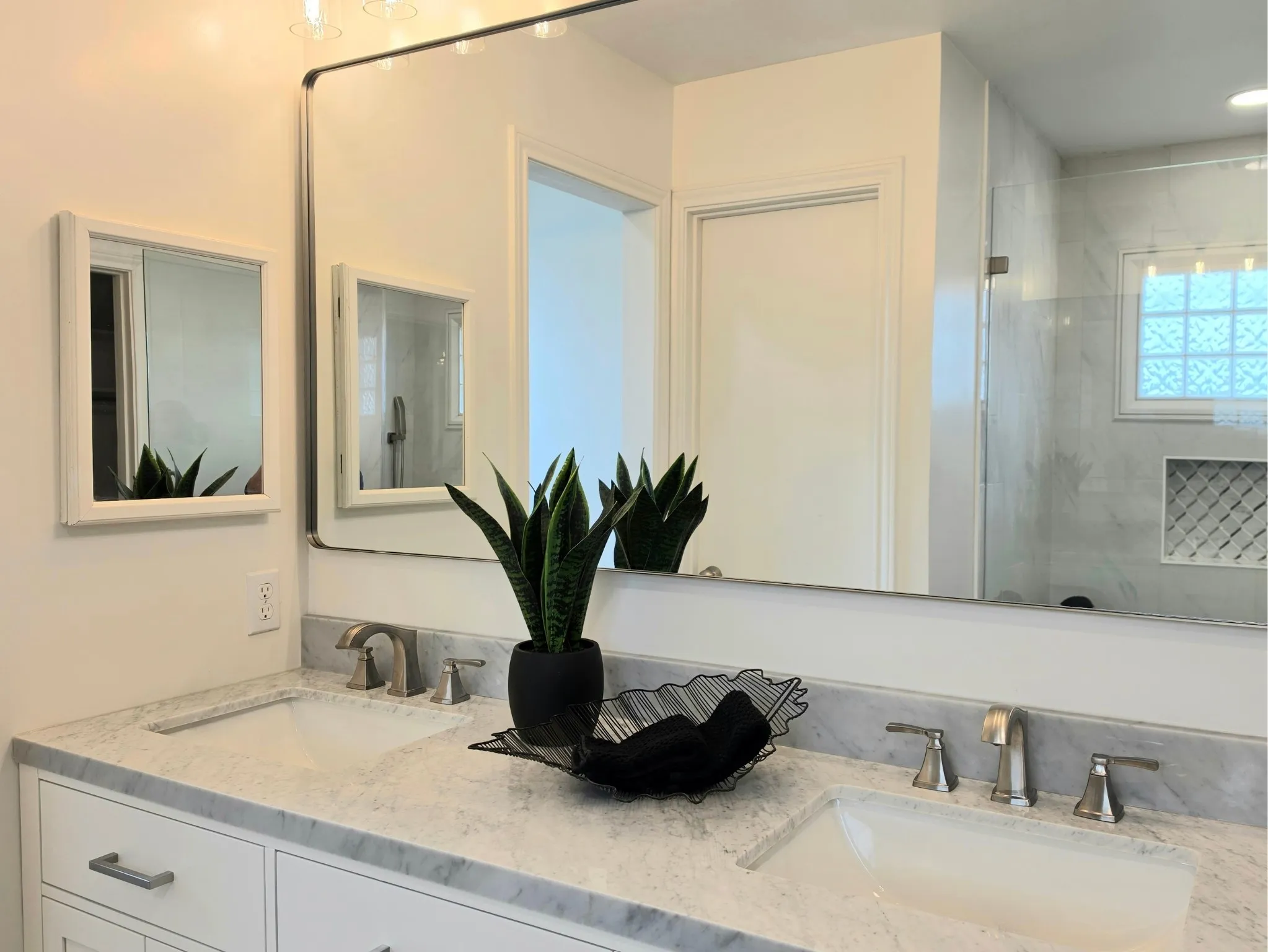 Dual undermount sinks with brushed nickel faucets, set in a light-colored stone countertop