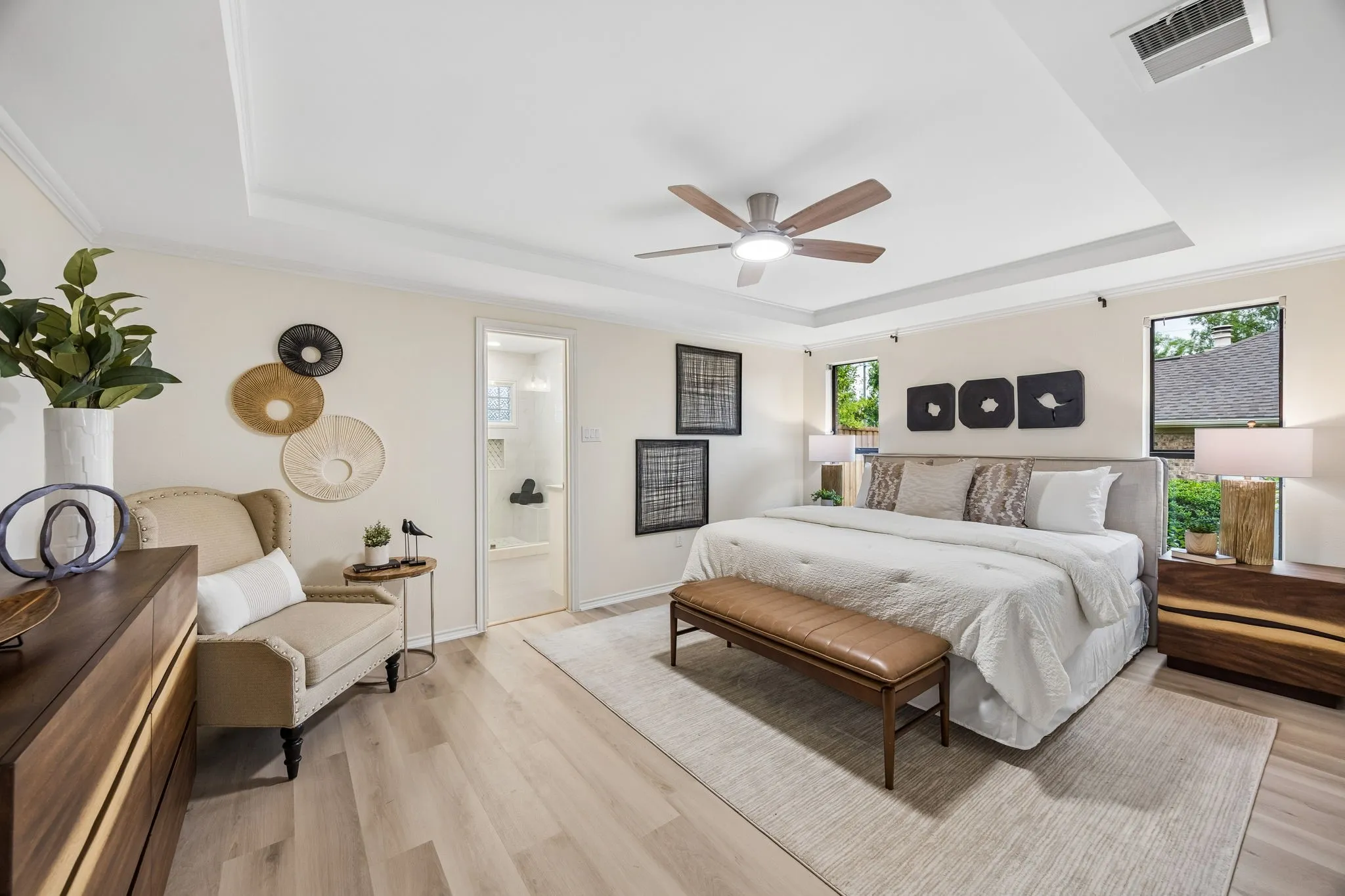 Tray ceiling with a ceiling fan, light wood-finish flooring, recessed windows, and white trim
