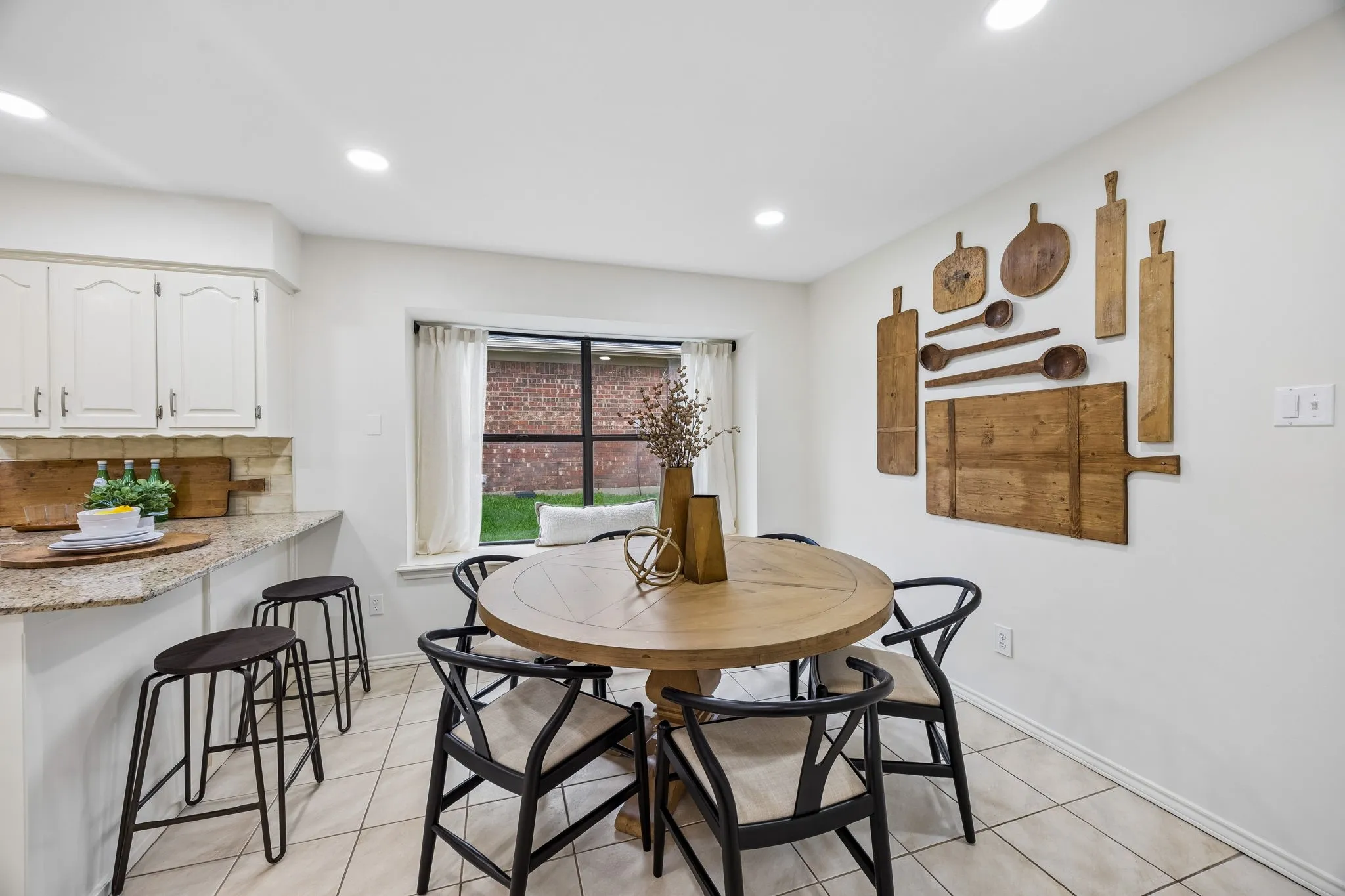 Recessed lighting, tile flooring, window with natural light, built-in breakfast bar, upper and lower cabinetry