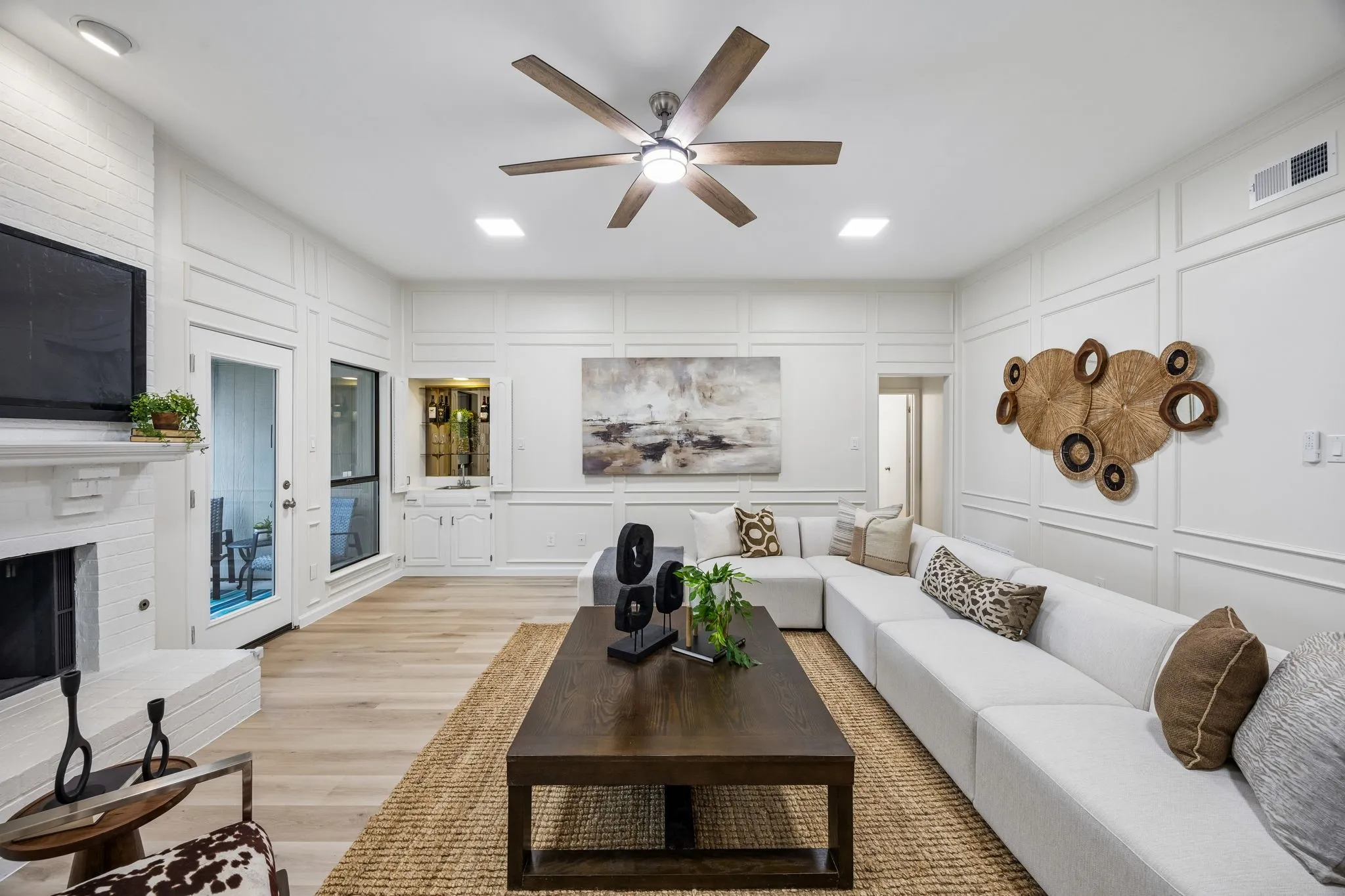 Living area featuring decorative wall paneling, wood-finish flooring, recessed lighting, and a ceiling fan