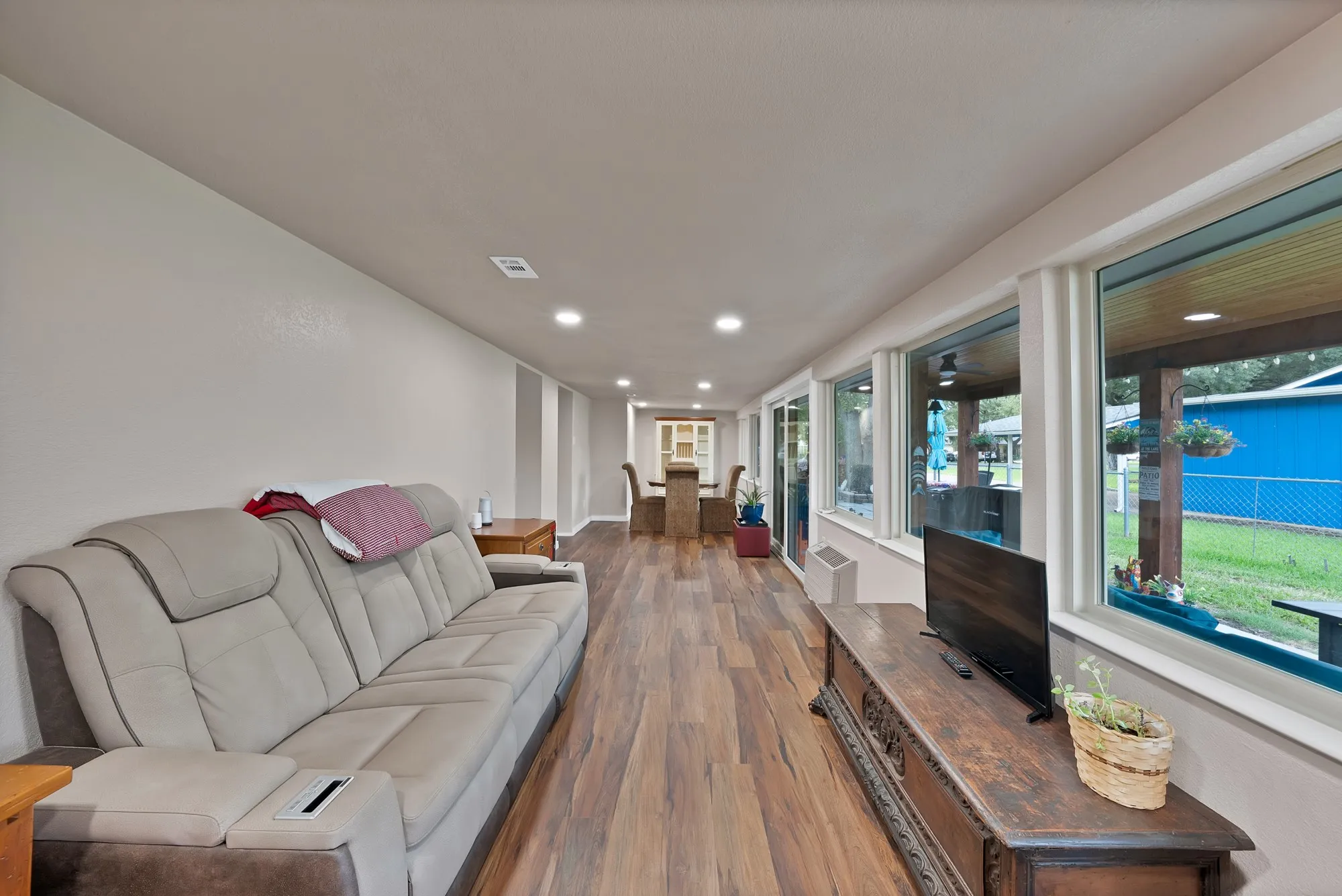 Wood-finish flooring throughout, recessed lighting, and a wall of windows featuring white trim