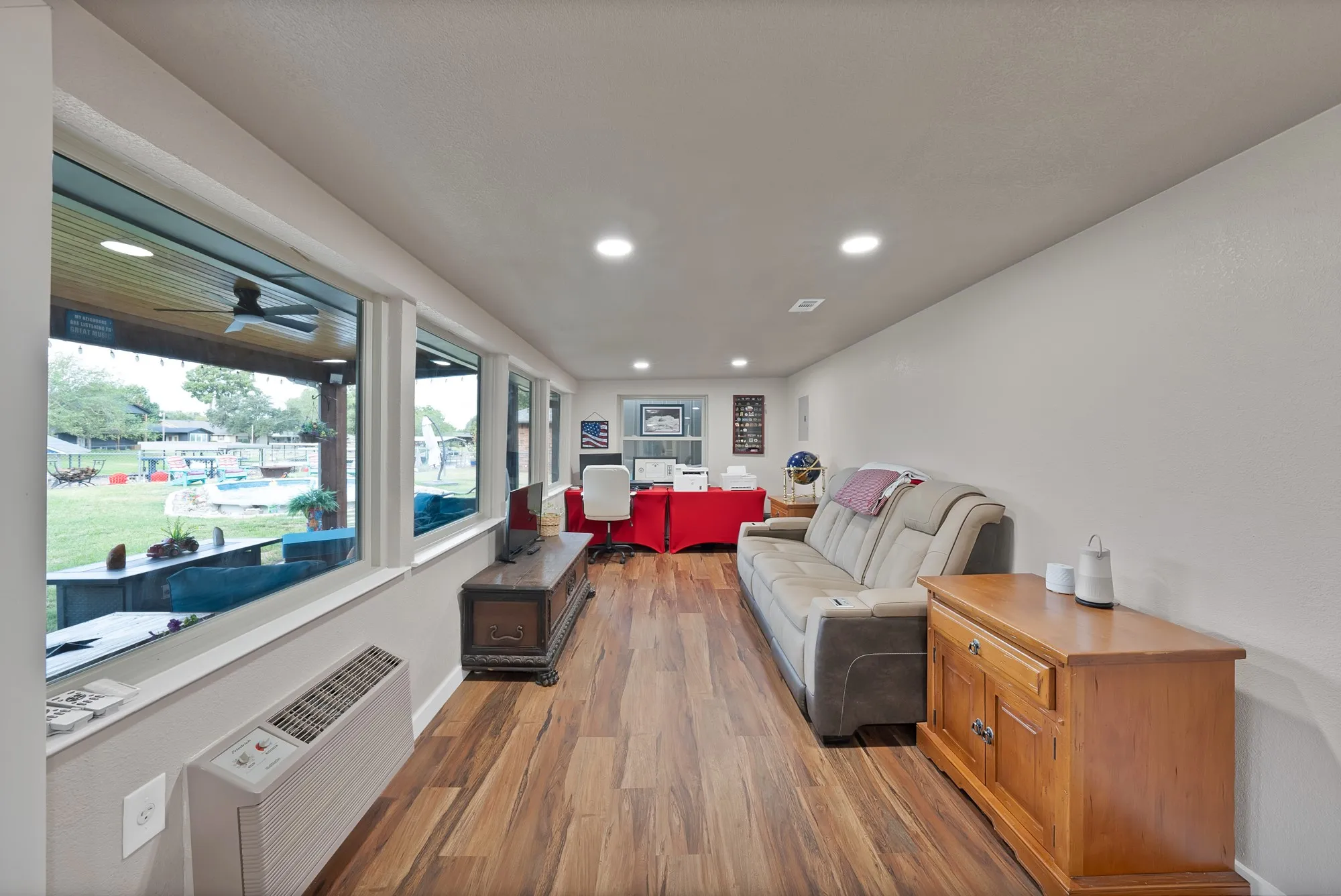 Wood-finish flooring, recessed ceiling lighting, and a window bank offering natural illumination