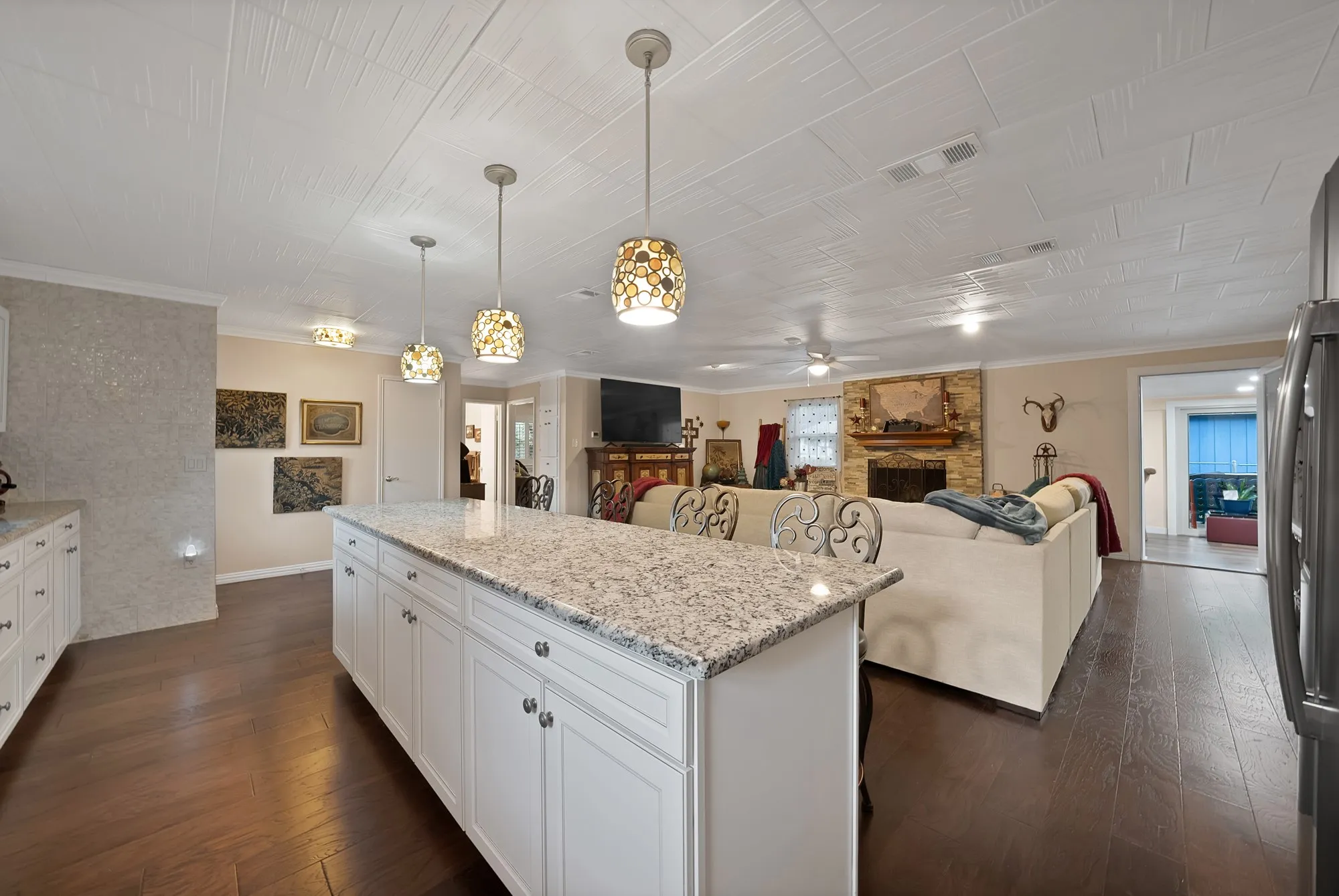 Expansive kitchen island with a light-toned granite countertop and white cabinetry