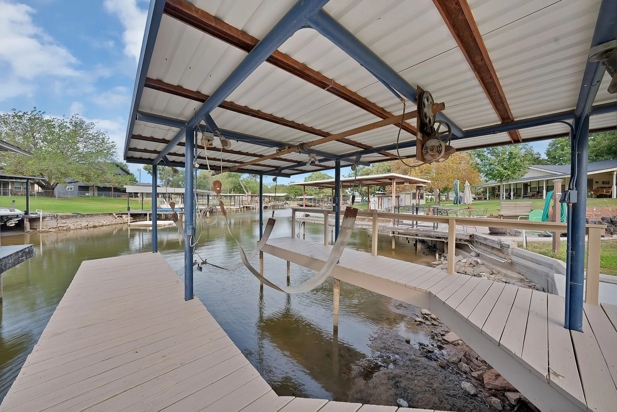 Covered boat dock with metal roof and beige composite decking