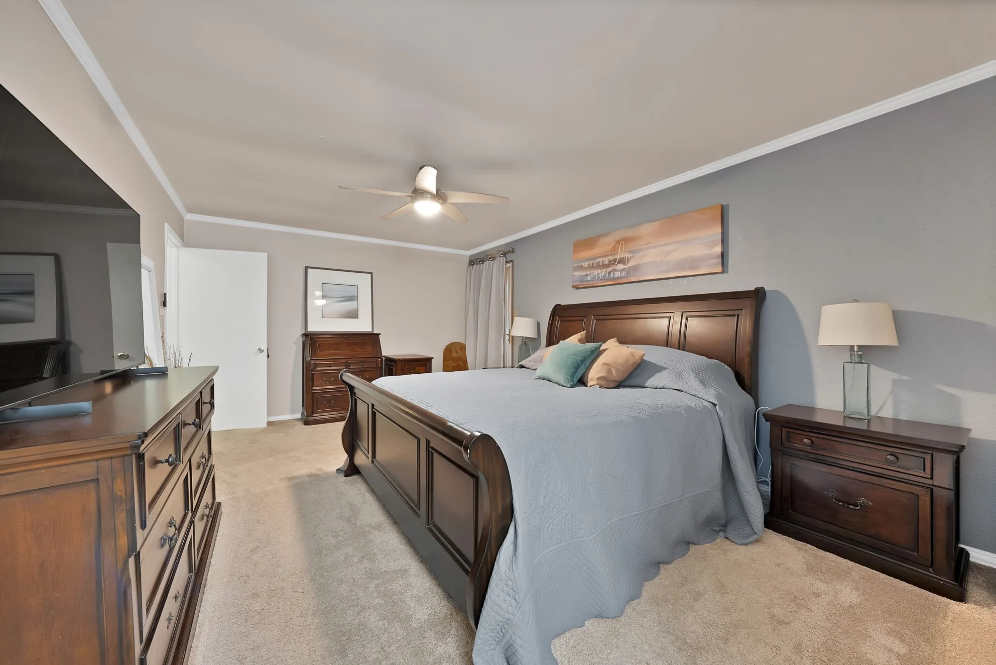 Neutral wall colors, crown molding, ceiling fan, and carpeted flooring
